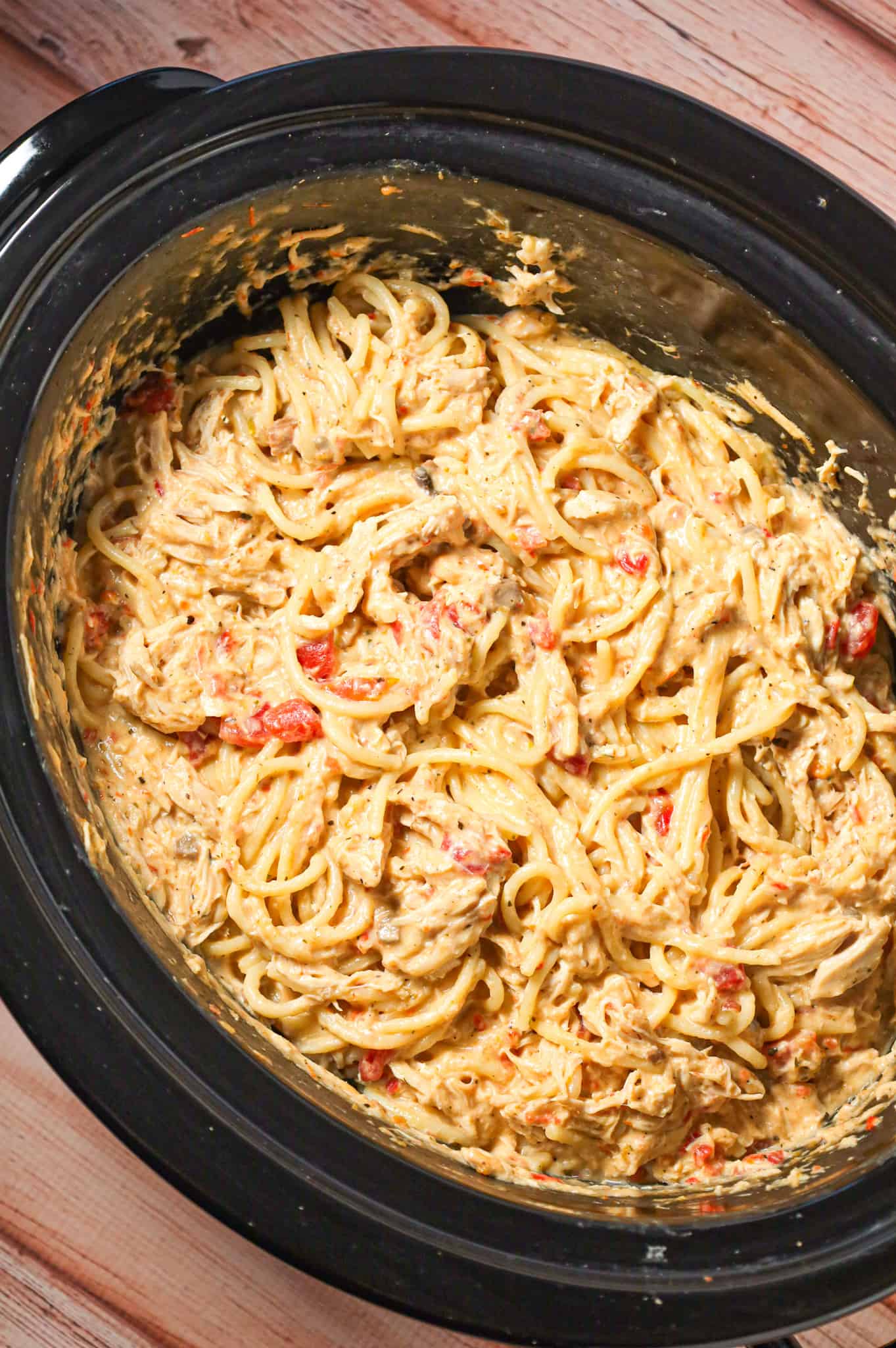 Crock Pot Chicken Spaghetti is a hearty slow cooker pasta recipe made with boneless, skinless chicken breasts cooked in a cream soup and cream cheese mixture and loaded with shredded cheese.