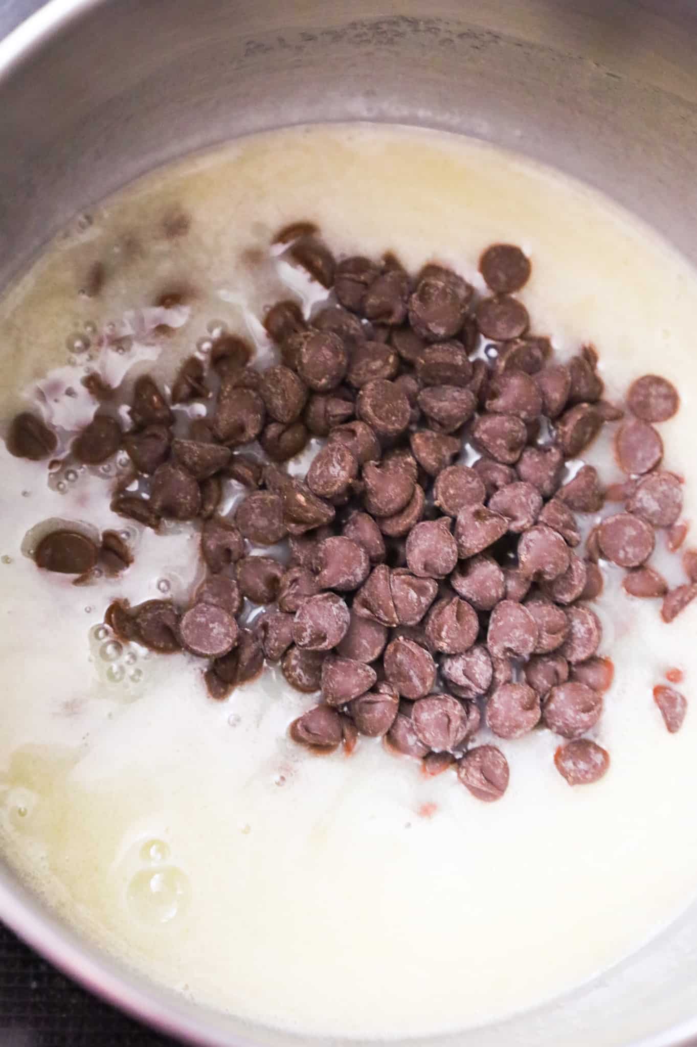 semi sweet chocolate chips added to a saucepan with a cream, butter and sugar mixture
