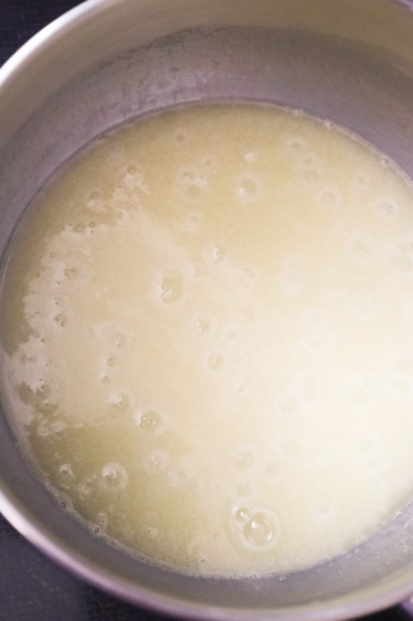 butter, sugar and cream mixture coming to a boil in a saucepan