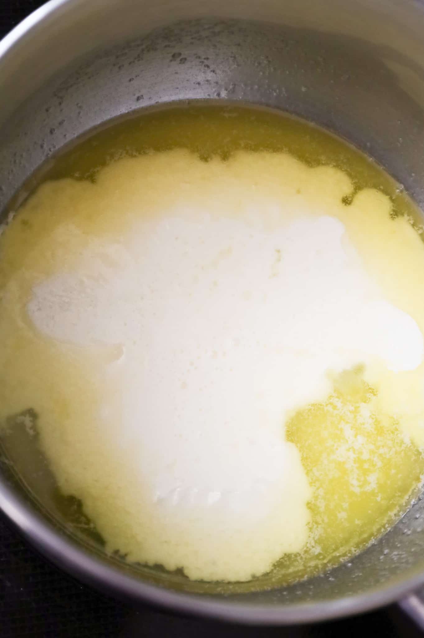 heavy cream added to saucepan with melted butter and sugar mixture