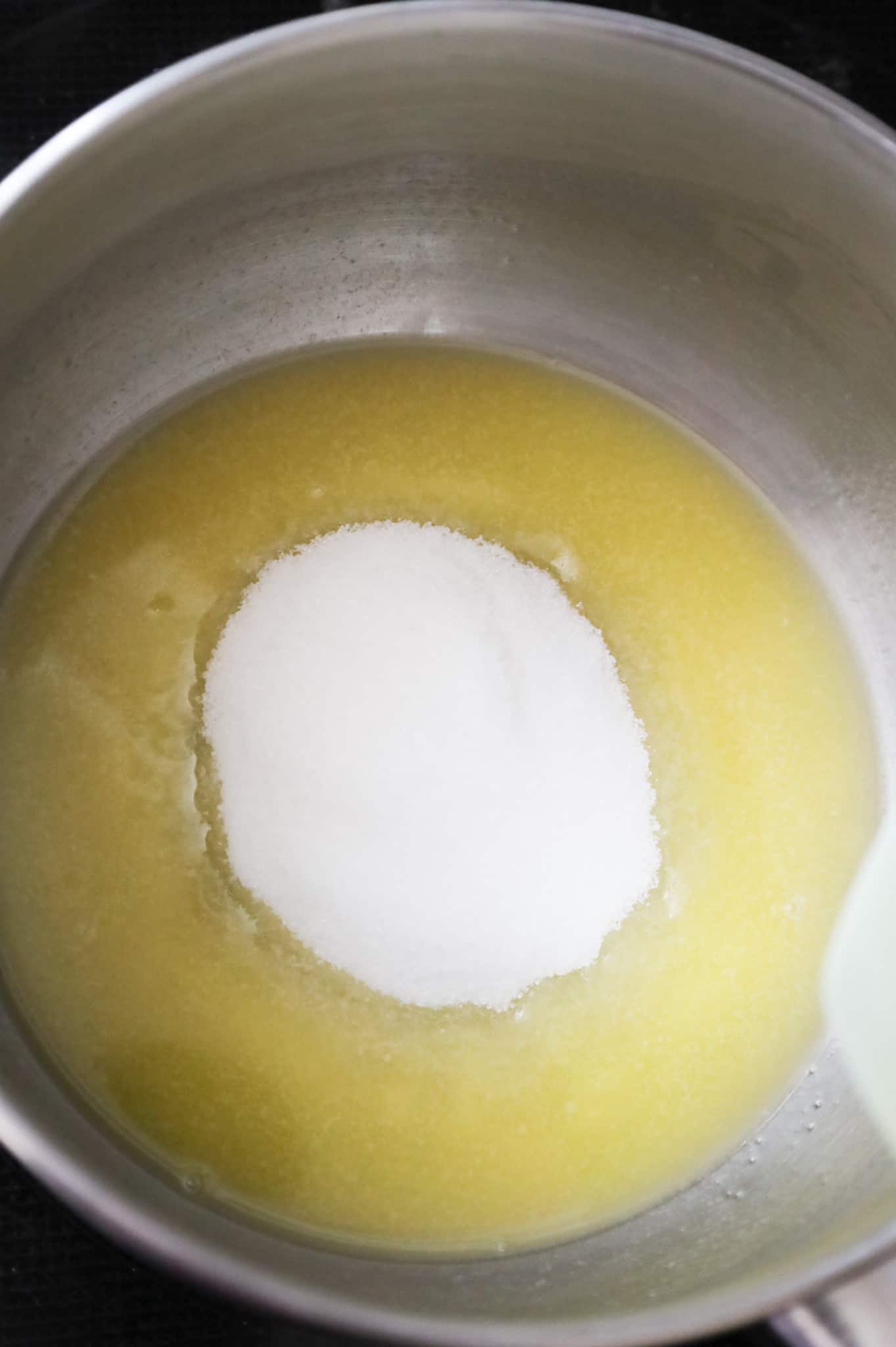 granulated sugar added to a saucepan with melted butter