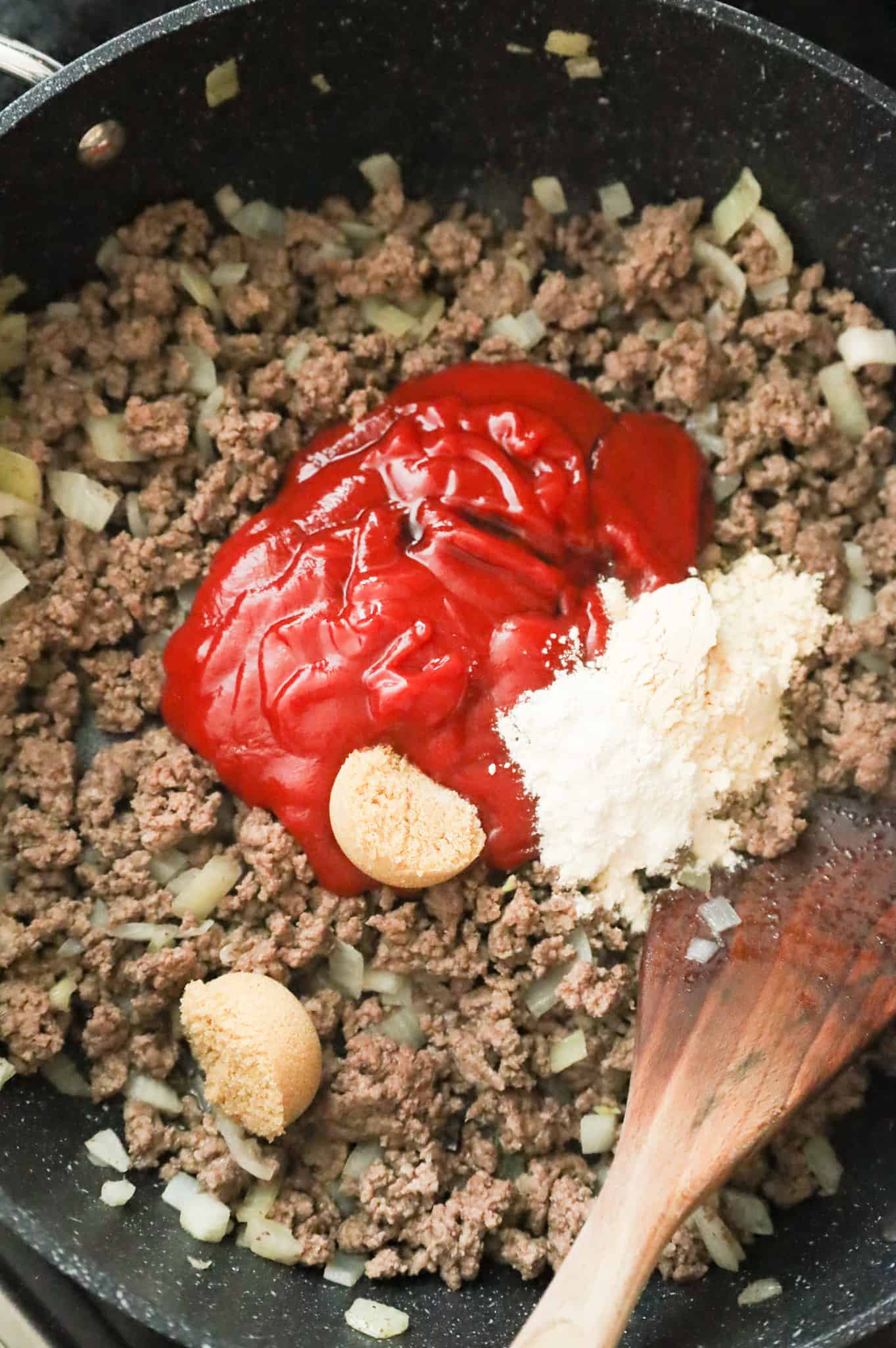 ketchup, Worcestershire sauce, brown sugar, onion powder and garlic powder on top of cooked ground beef in a skillet