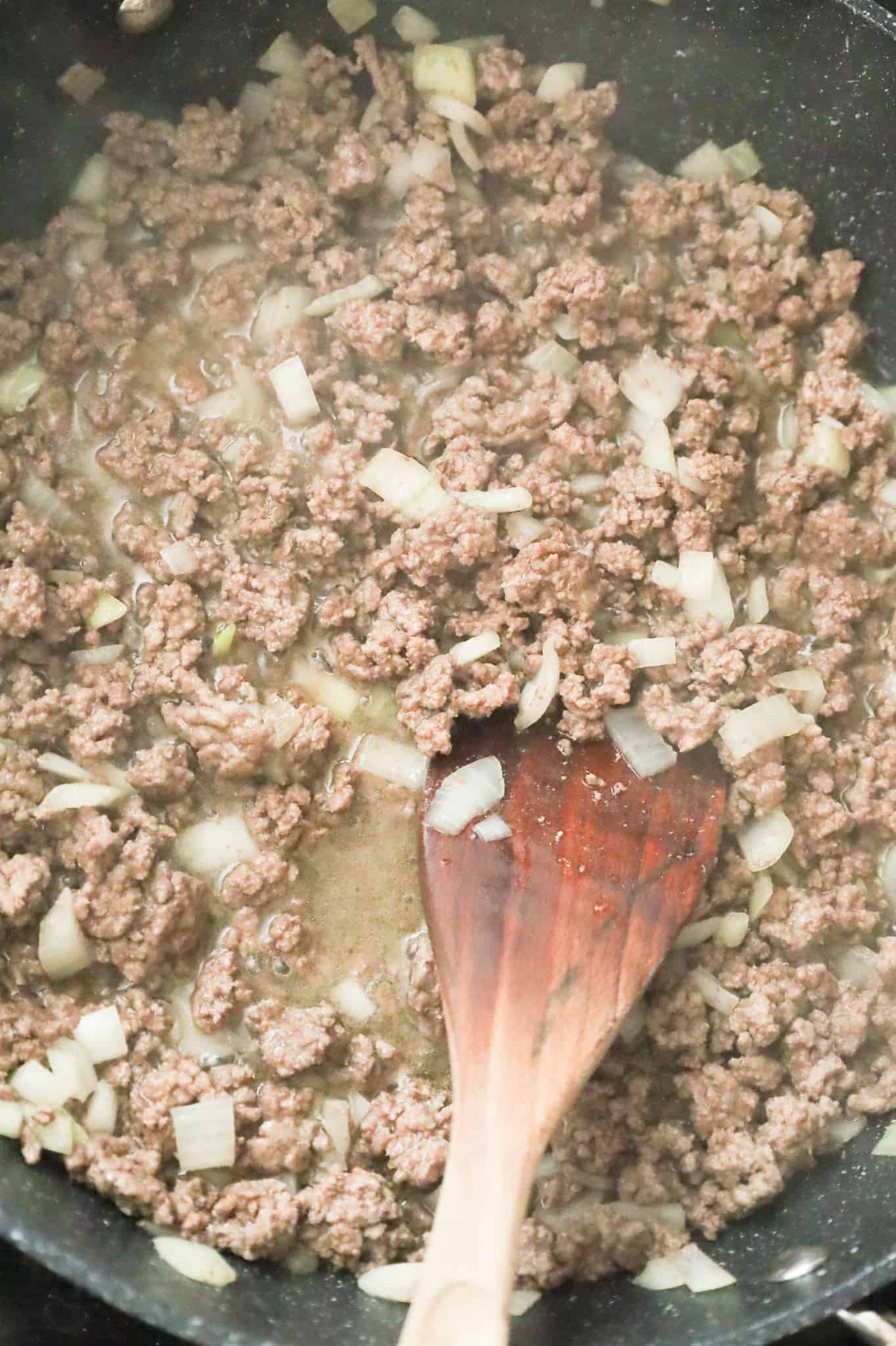 diced onions and ground beef cooking in a skillet