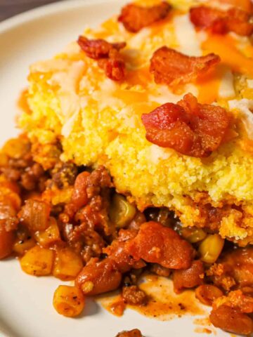 Cowboy Cornbread Casserole is an easy ground beef casserole recipe loaded with bacon, baked beans and corn with Jiffy cornbread baked on top.