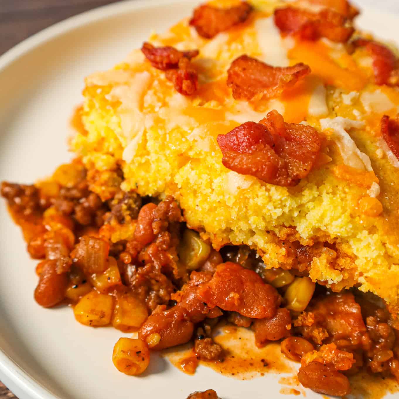 Cowboy Cornbread Casserole is an easy ground beef casserole recipe loaded with bacon, baked beans and corn with Jiffy cornbread baked on top.