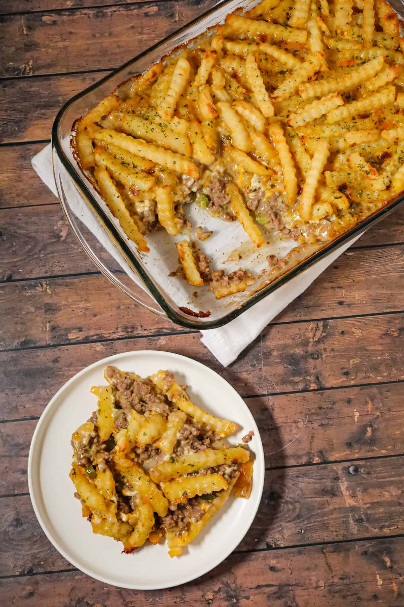 French Fry Casserole is a hearty ground beef casserole made with cream of mushroom soup, cheddar soup, diced onions, green peppers and shredded cheese all topped with crinkle cut fries.