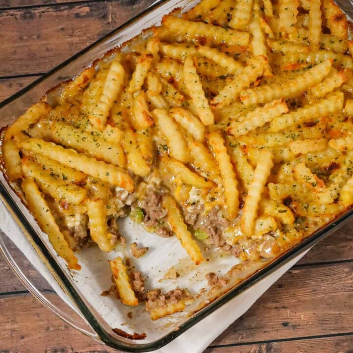 French Fry Casserole is a hearty ground beef casserole made with cream of mushroom soup, cheddar soup, diced onions, green peppers and shredded cheese all topped with crinkle cut fries.