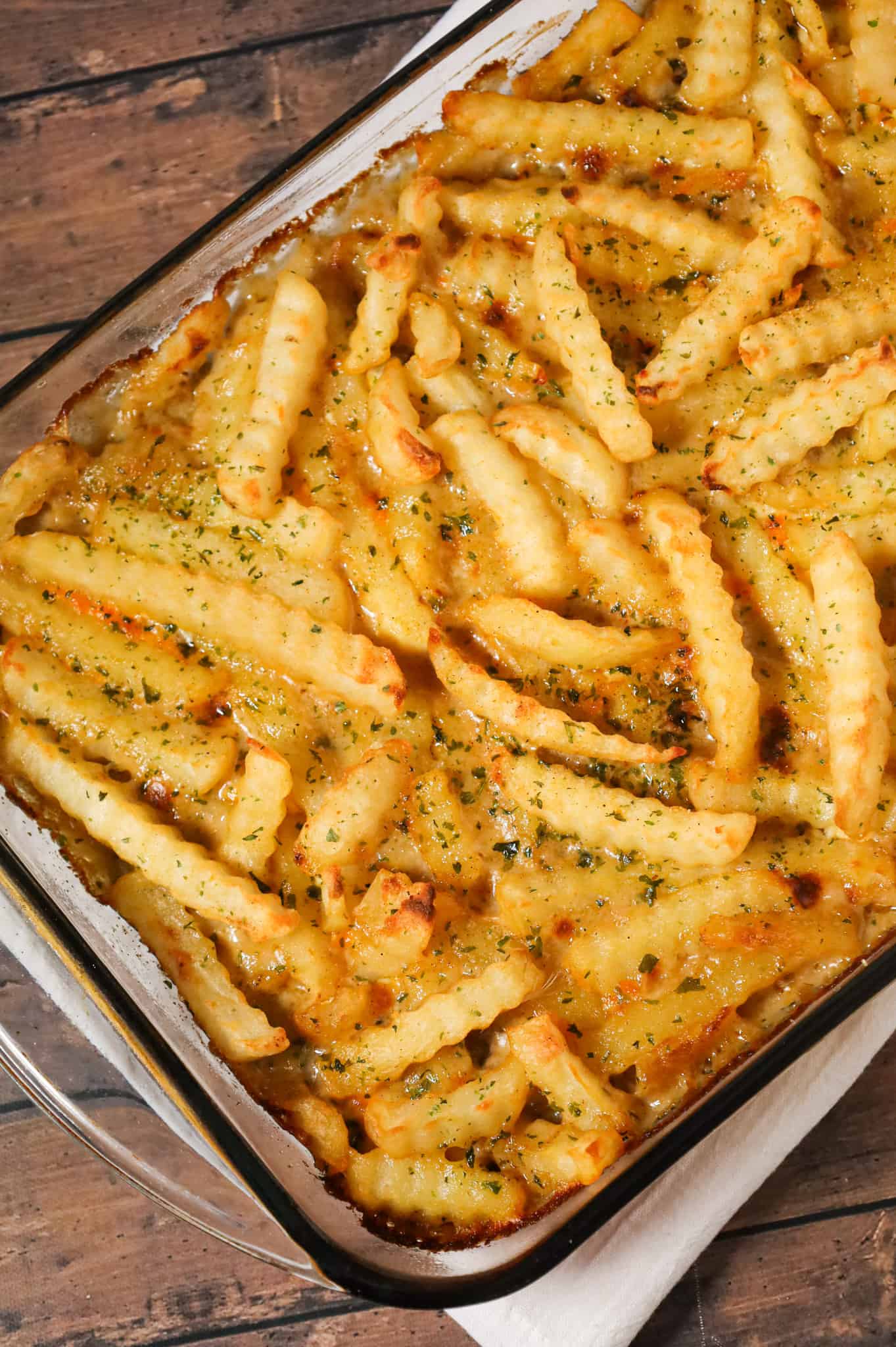 French Fry Casserole is a hearty ground beef casserole made with cream of mushroom soup, cheddar soup, diced onions, green peppers and shredded cheese all topped with crinkle cut fries.
