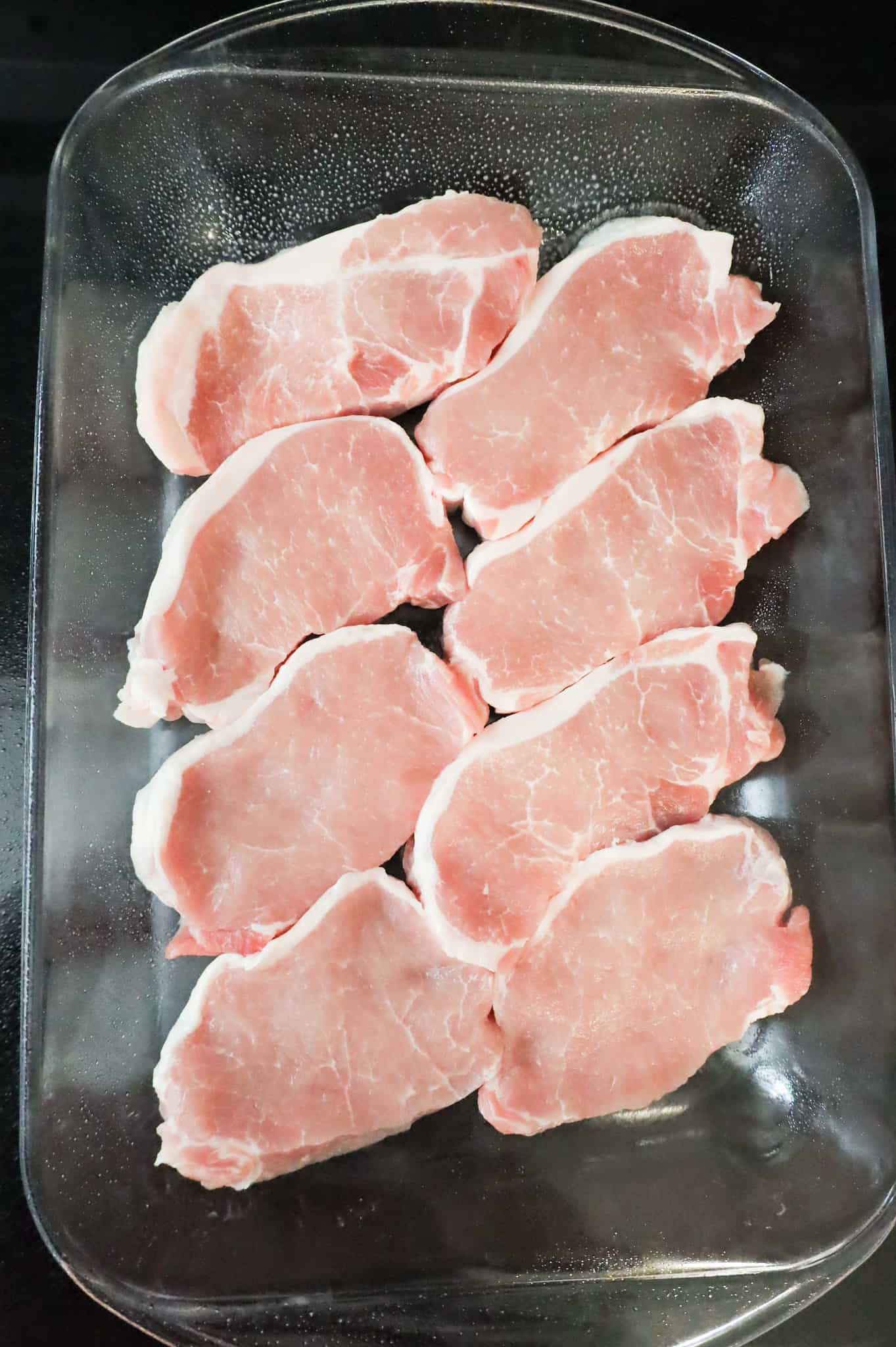 raw pork chops in a baking dish