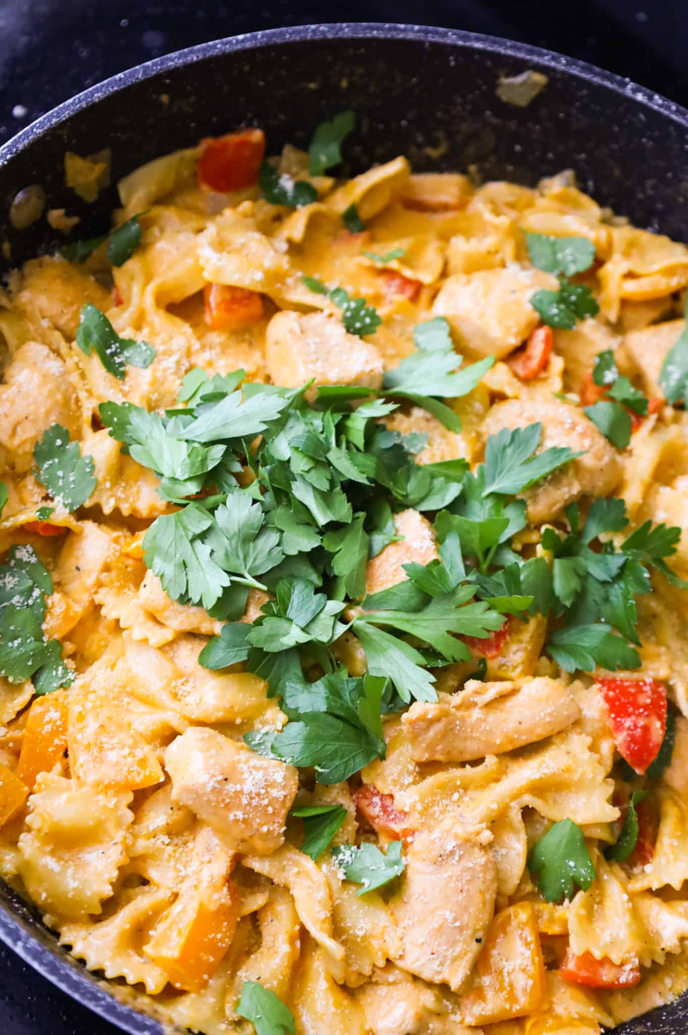 chopped parsley on top of chicken chipotle pasta in a skillet