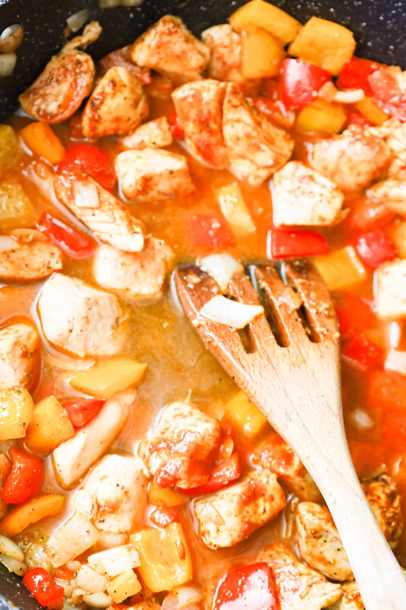 chicken broth and chipotle pepper sauce added to skillet with diced pepper and chicken breast chunks in a skillet