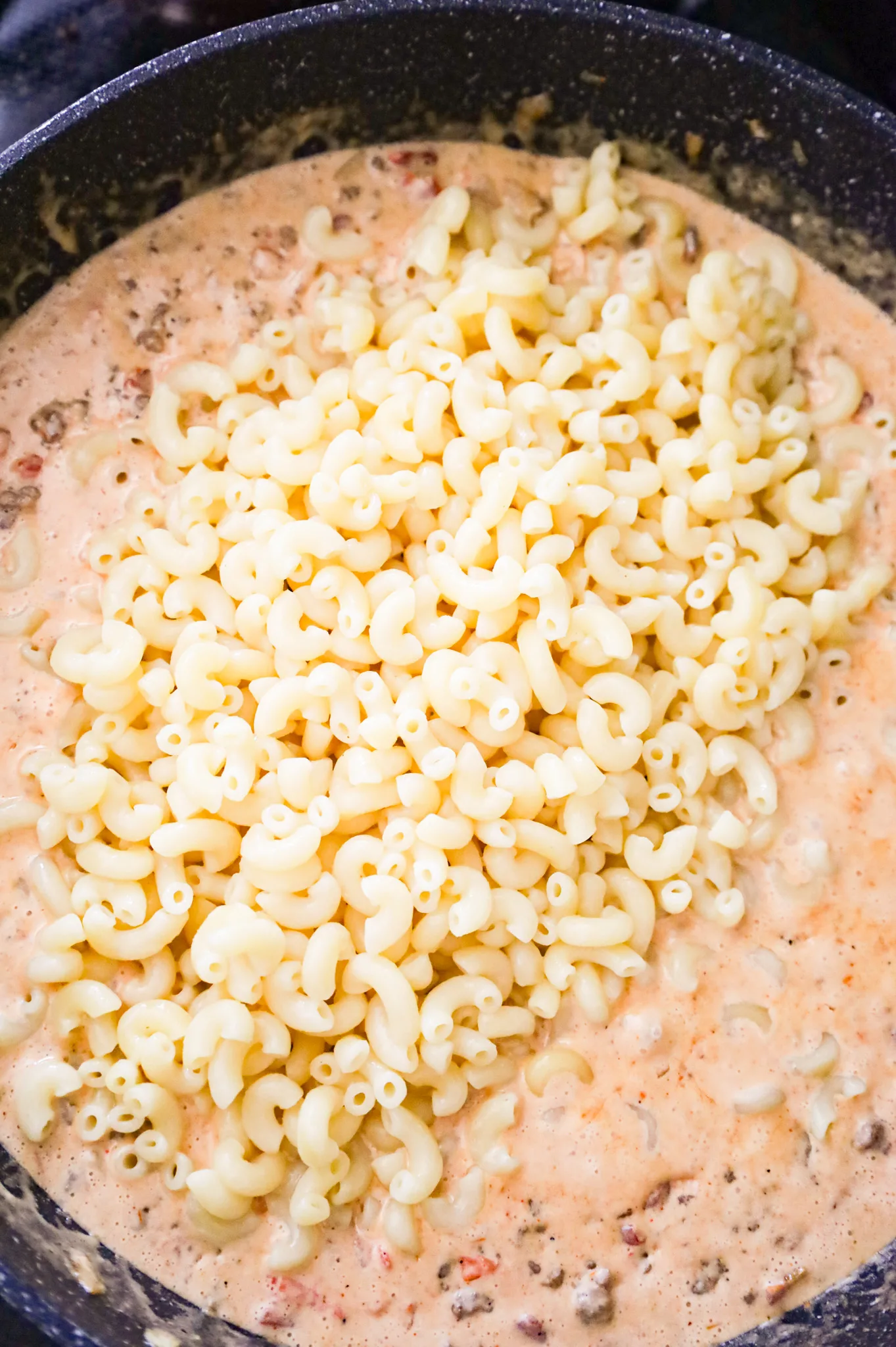 cooked macaroni noodles added to skillet with creamy taco sauce