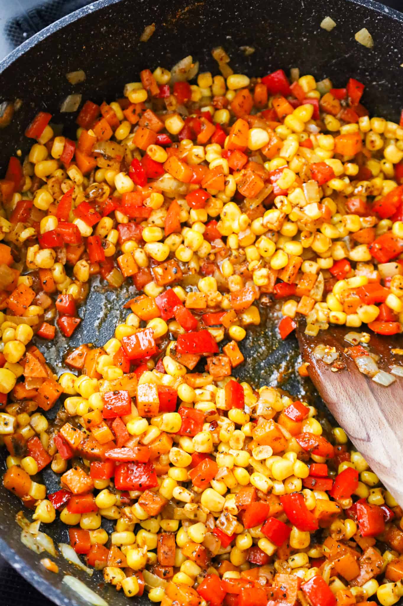 Cajun seasoned corn, diced peppers and diced sweet potatoes in a skillet