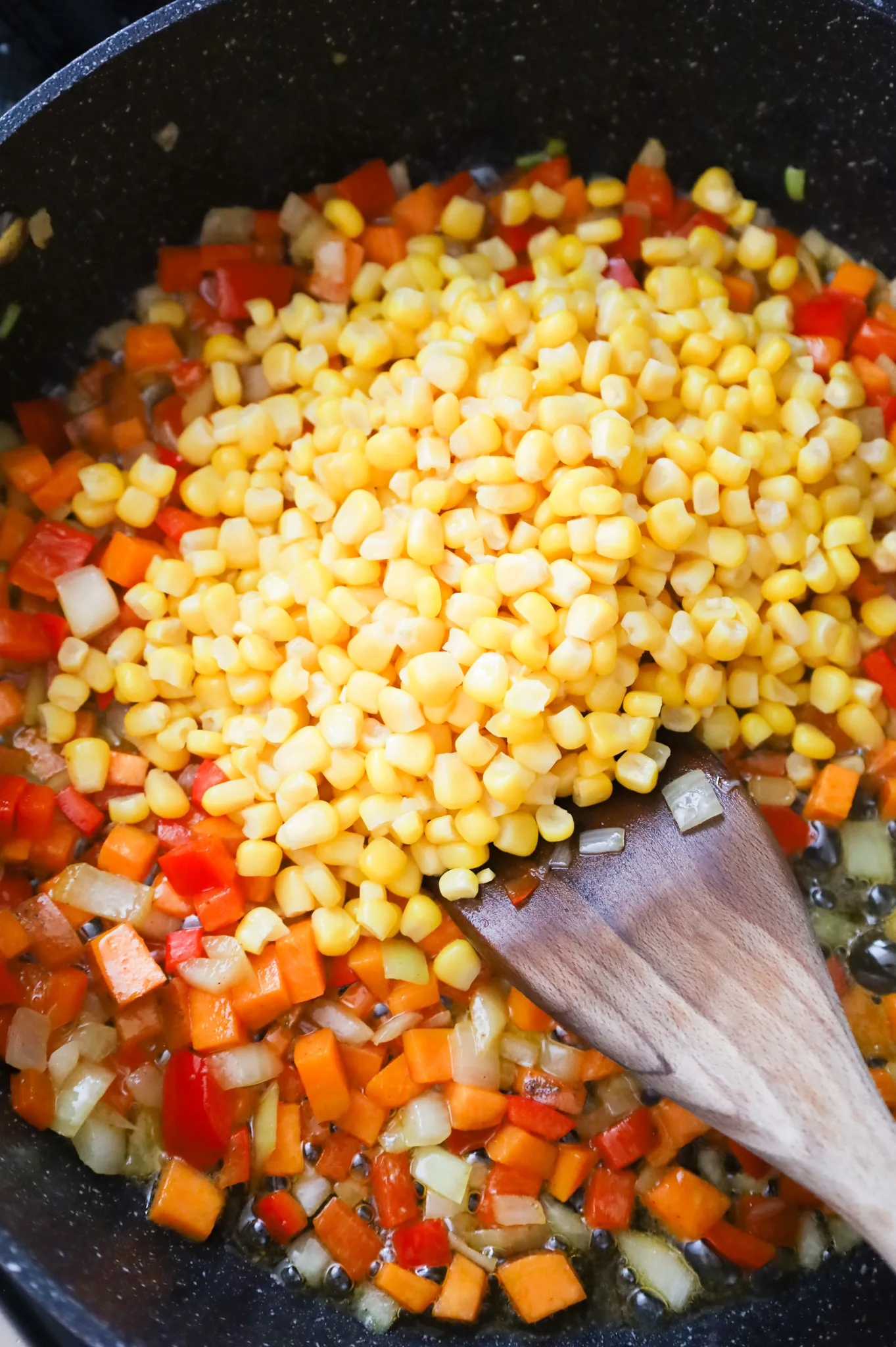 canned corn added to skillet with diced peppers, onions and sweet potatoes