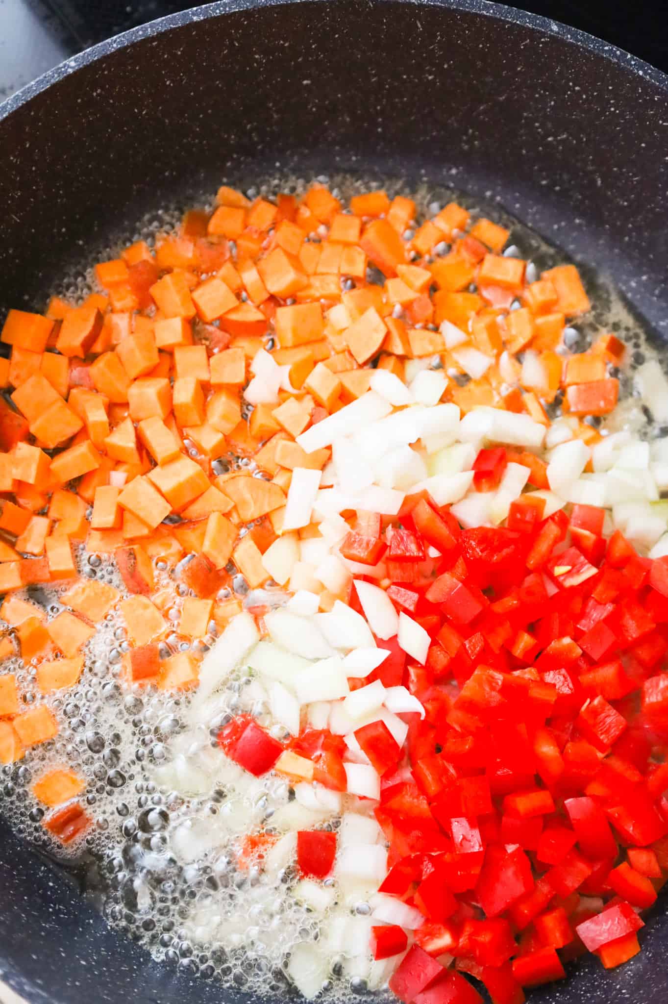 diced sweet potatoes, diced onions and diced red peppers added to the skillet with the bacon grease