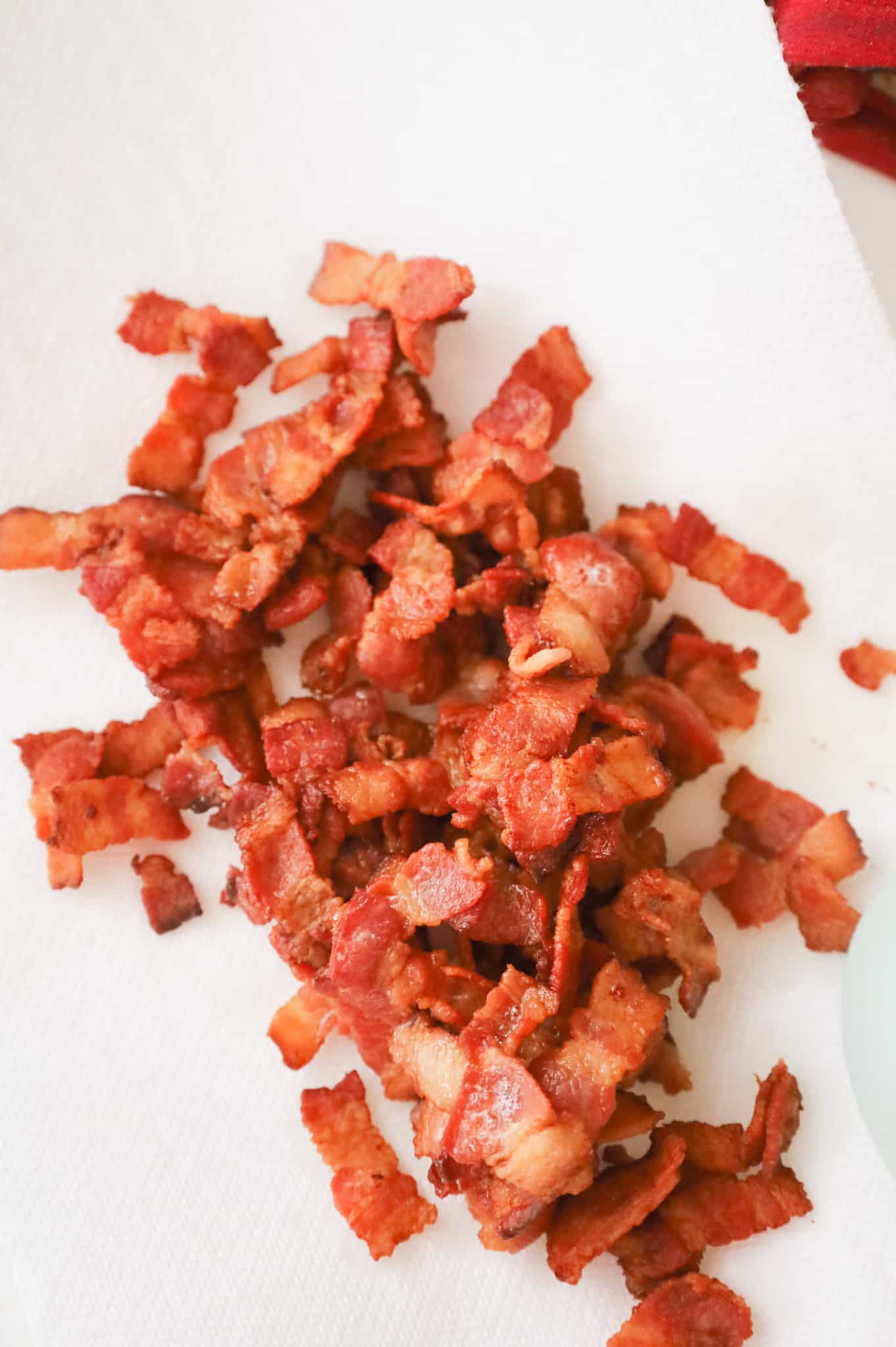 cooked bacon pieces on a paper towel lined plate