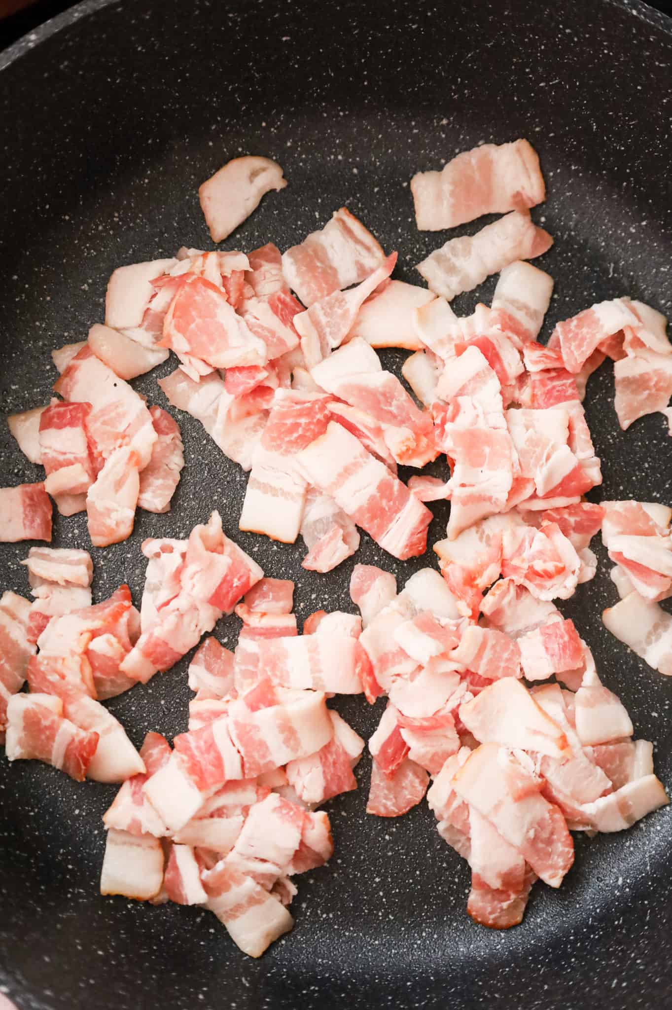 chopped bacon pieces added to a skillet