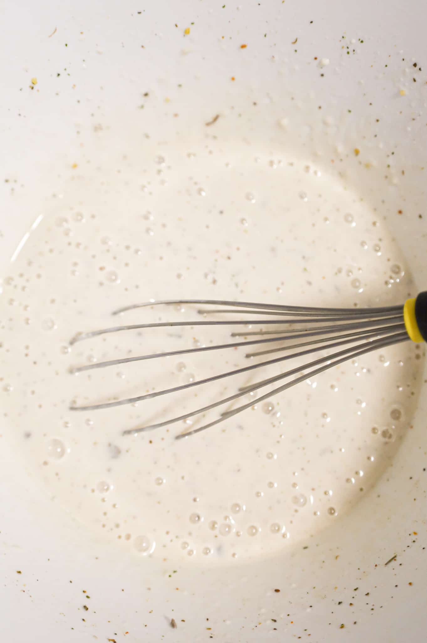 cream of mushroom soup mixture being whisked in a mixing bowl