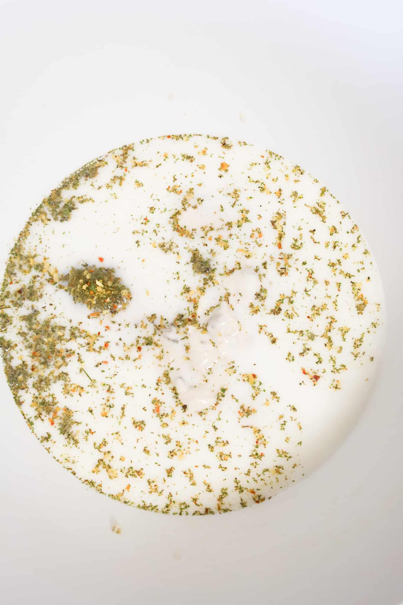 Italian seasoning, milk, water and cream of mushroom soup in a mixing bowl