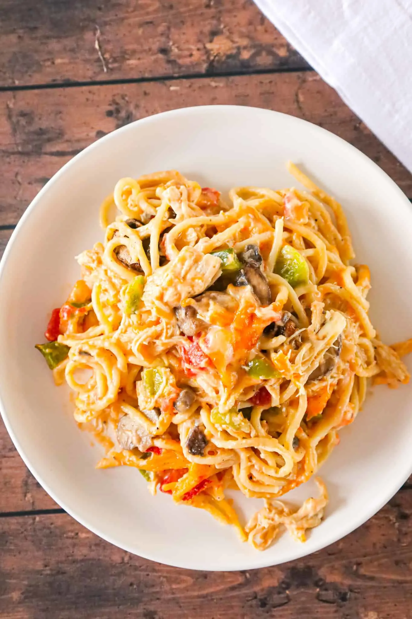 Texas Chicken Spaghetti is a hearty baked pasta recipe loaded with shredded chicken, cream of mushroom soup, cream of chicken soup, Rotel diced tomatoes and green chilies, diced green peppers, sliced mushrooms and shredded cheese.