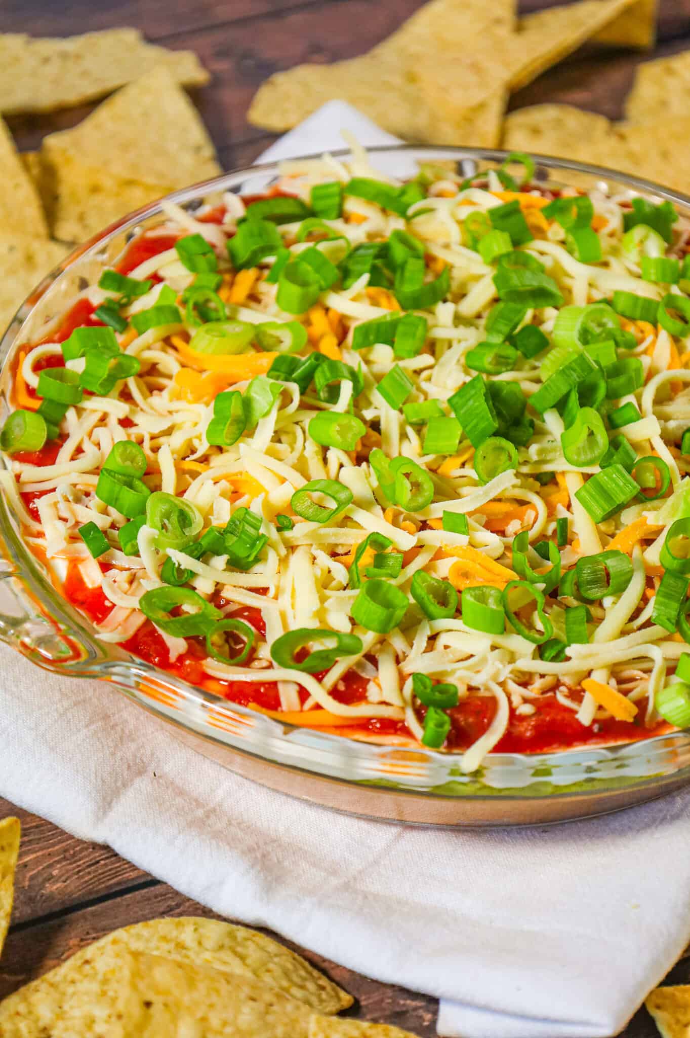  5 Layer Dip is a delicious cold dip recipe made with refried beans, cream cheese, taco seasoning, guacamole, sour cream, salsa, shredded cheese and chopped green onions.