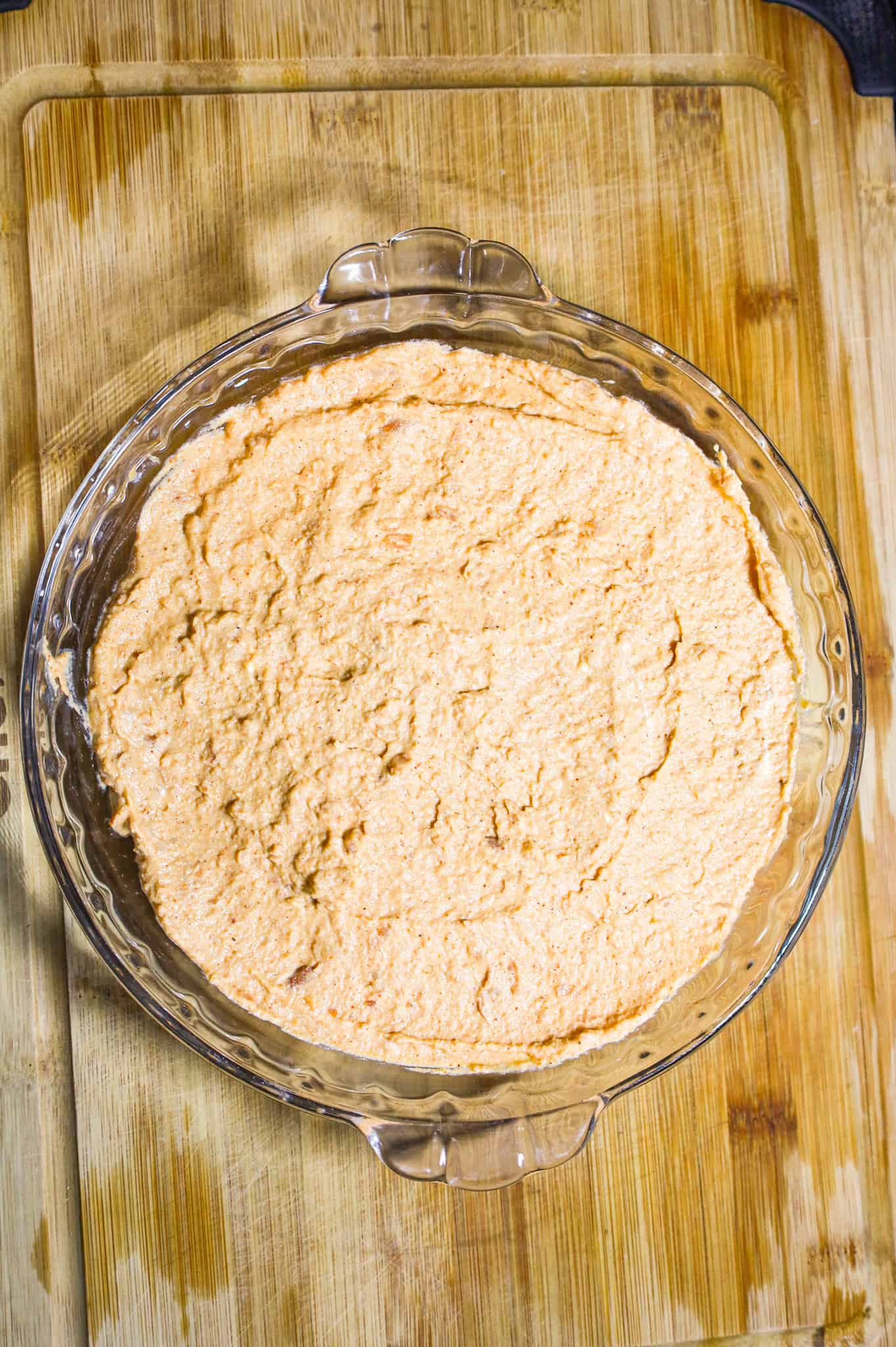 refried bean and cream cheese mixture in a glass pie plate