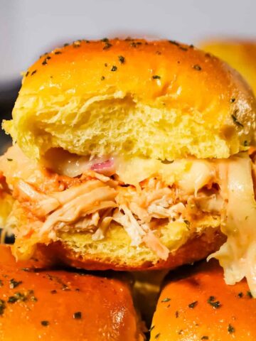 BBQ Chicken Sliders are an easy weeknight dinner recipe using rotisserie chicken tossed in BBQ sauce and baked on dinner rolls with Monterey Jack cheese.