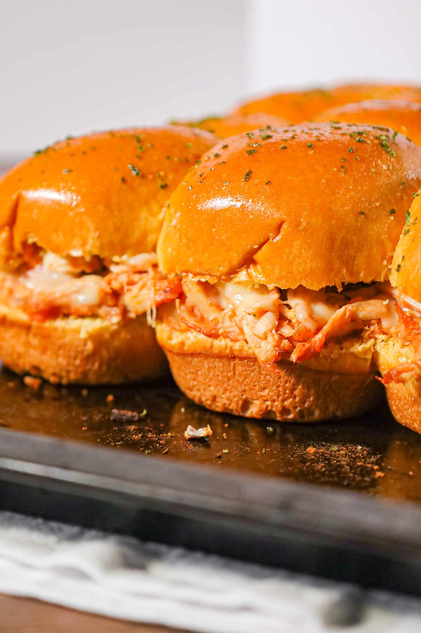 BBQ Chicken Sliders are an easy weeknight dinner recipe using rotisserie chicken tossed in BBQ sauce and baked on dinner rolls with Monterey Jack cheese.