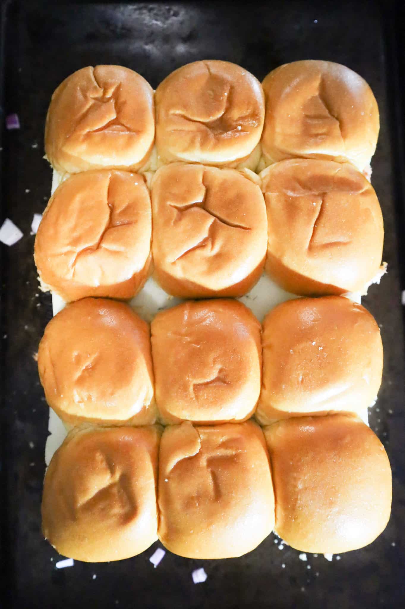 cheesy chicken sliders on a baking sheet before baking