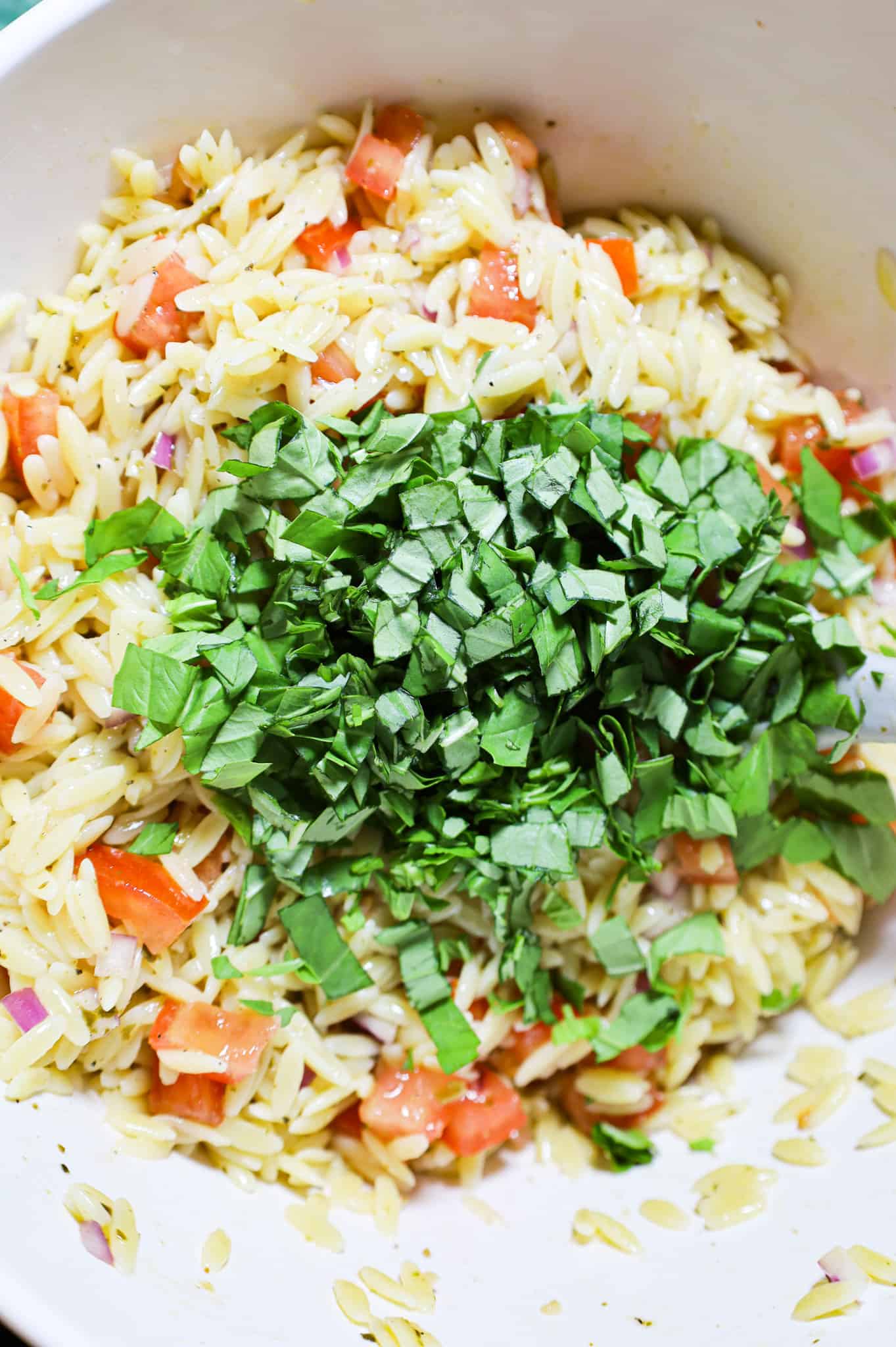 chopped fresh basil added to orzo salad mixture