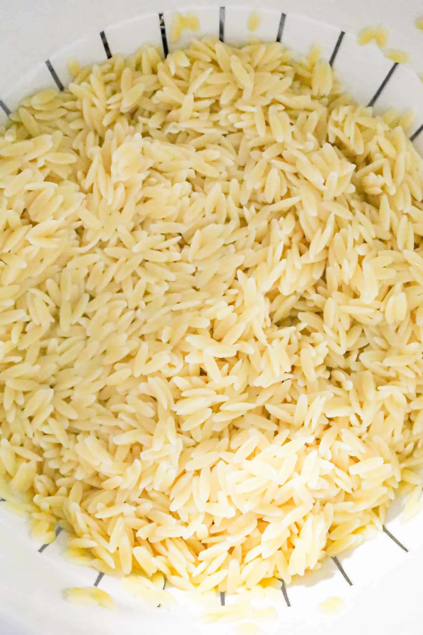 cooked orzo noodles in a colander