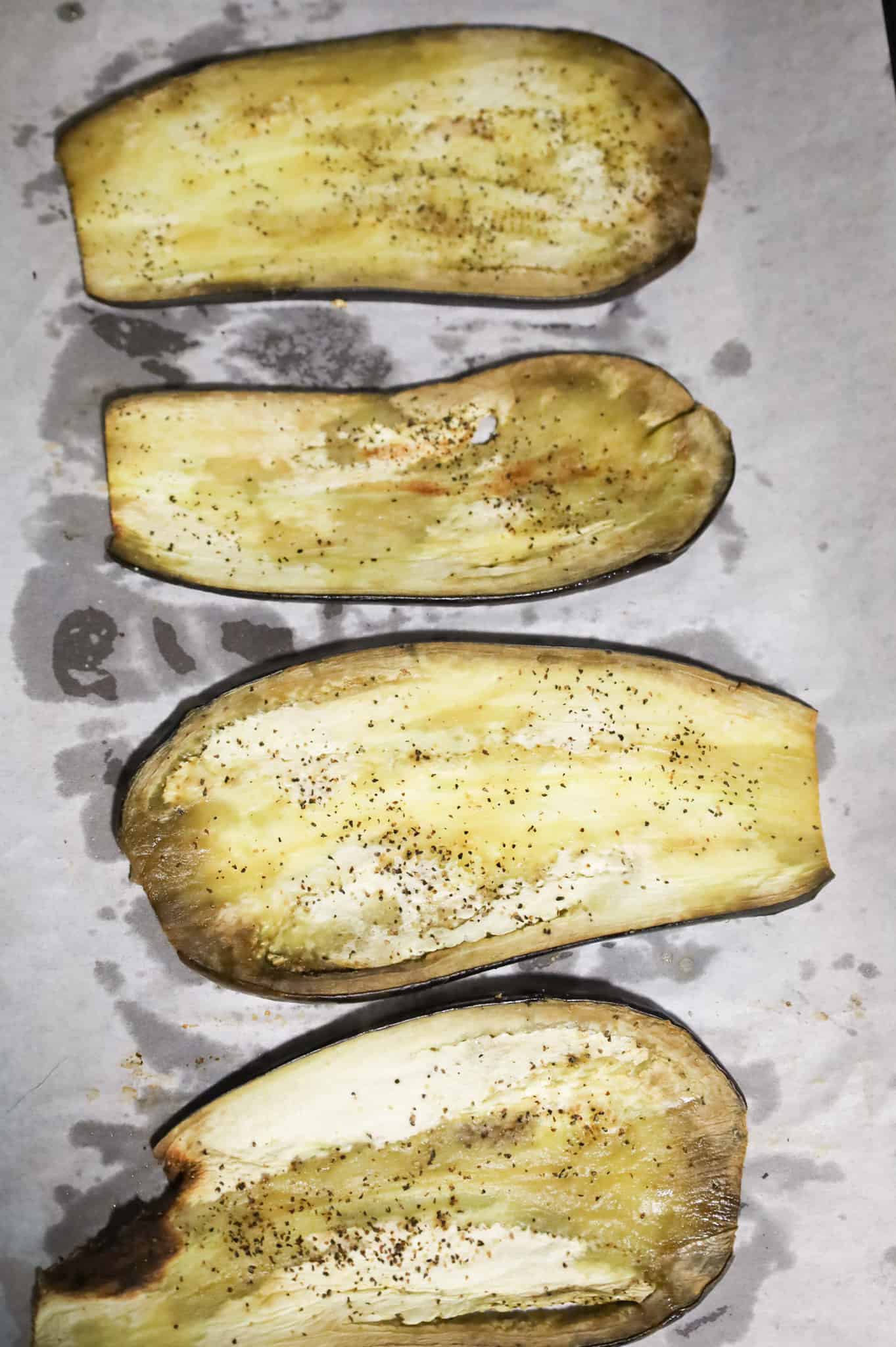 roasted eggplant slices on a parchment lined baking sheet