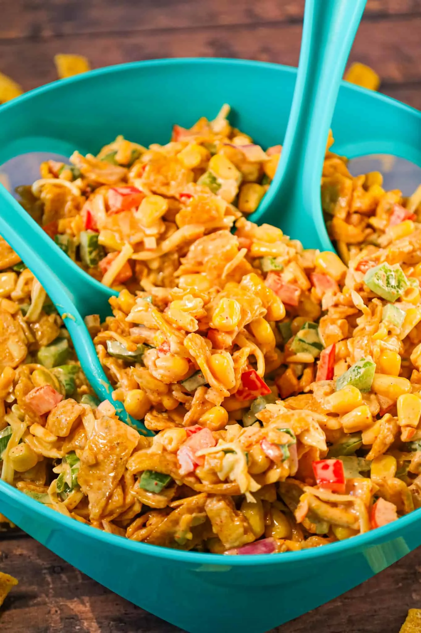 Frito Corn Salad is a delicious side dish recipe loaded with corn, diced bell peppers, onions, shredded cheese and corn chips all tossed in a creamy mixture of mayo, ranch dressing and taco seasoning.