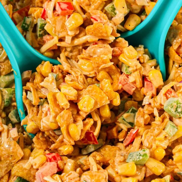 Frito Corn Salad is a delicious side dish recipe loaded with corn, diced bell peppers, onions, shredded cheese and corn chips all tossed in a creamy mixture of mayo, ranch dressing and taco seasoning.