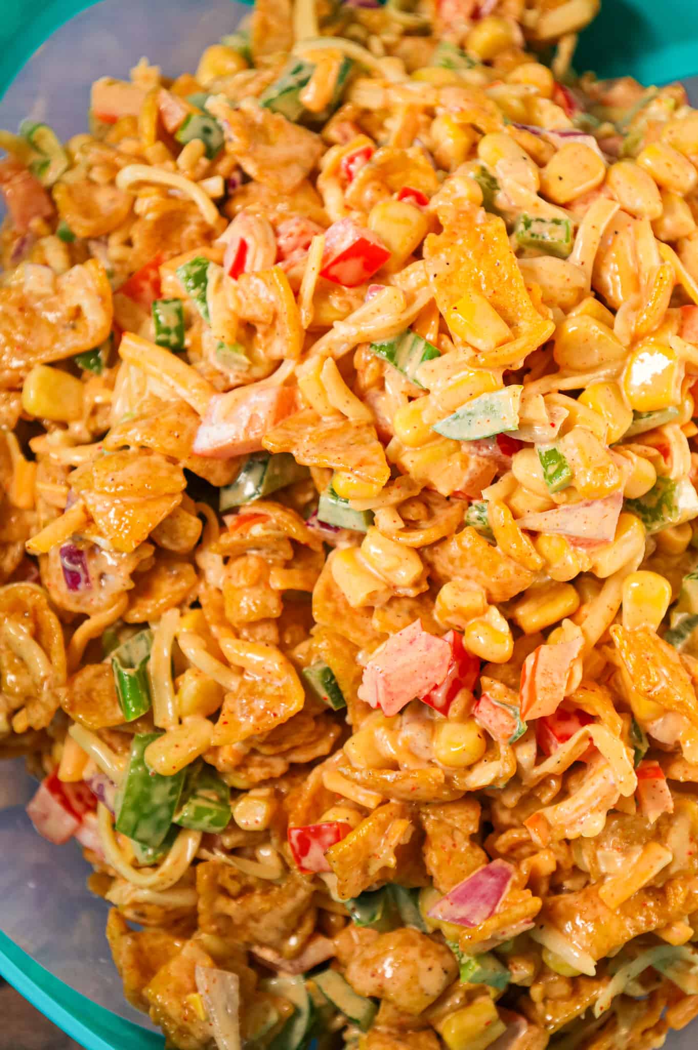 Frito Corn Salad is a delicious side dish recipe loaded with corn, diced bell peppers, onions, shredded cheese and corn chips all tossed in a creamy mixture of mayo, ranch dressing and taco seasoning.