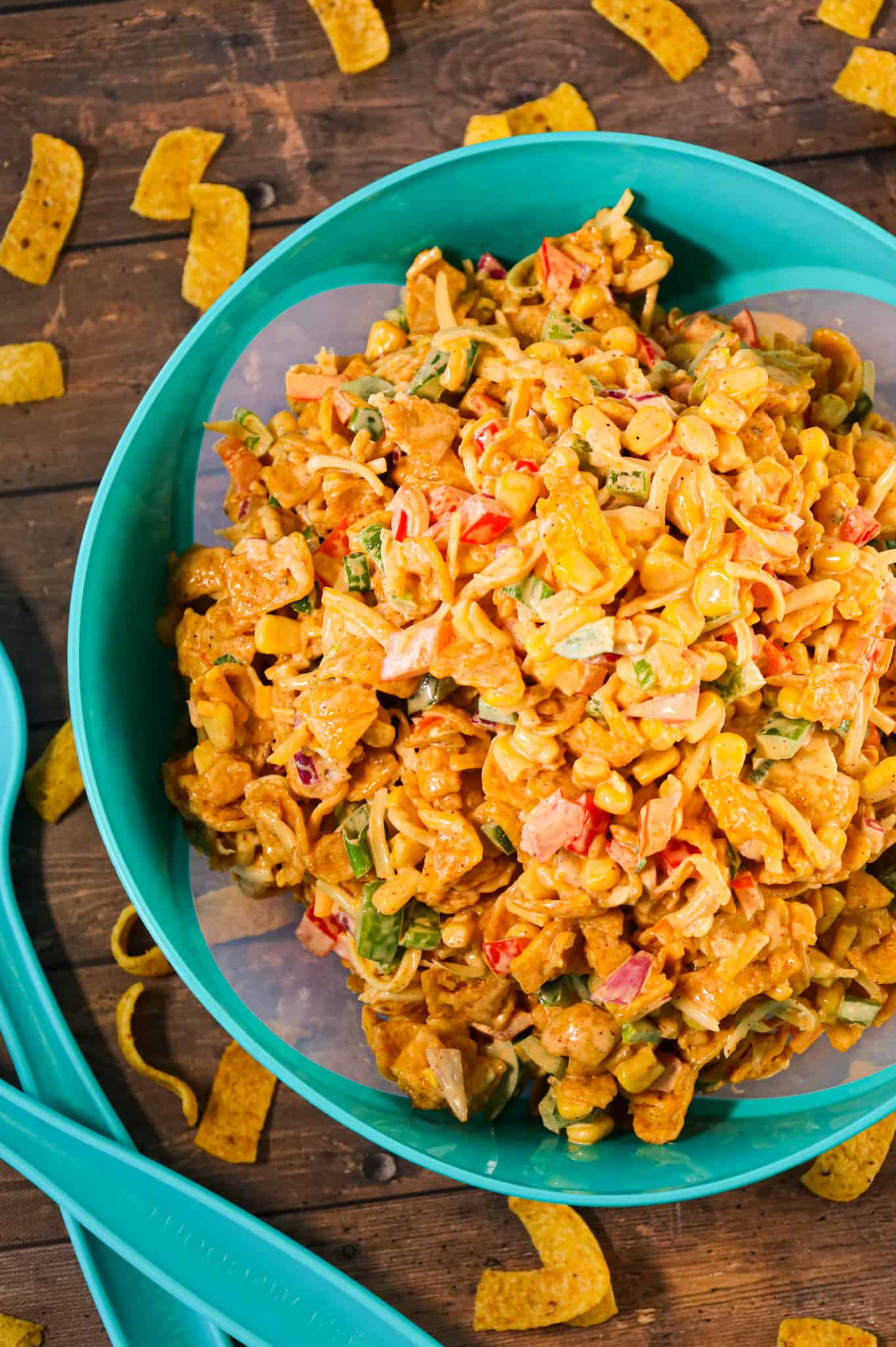 Frito Corn Salad is a delicious side dish recipe loaded with corn, diced bell peppers, onions, shredded cheese and corn chips all tossed in a creamy mixture of mayo, ranch dressing and taco seasoning.