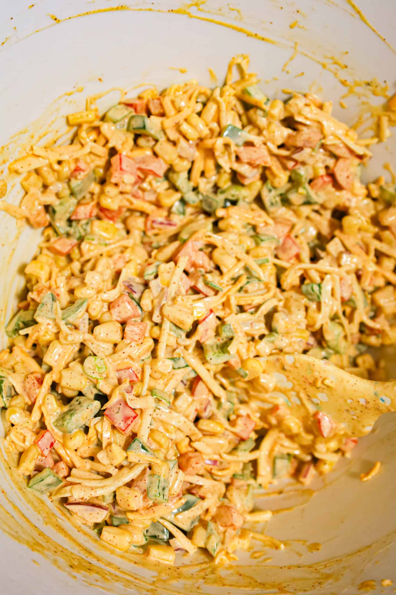 cheesy corn salad mixture in a mixing bowl