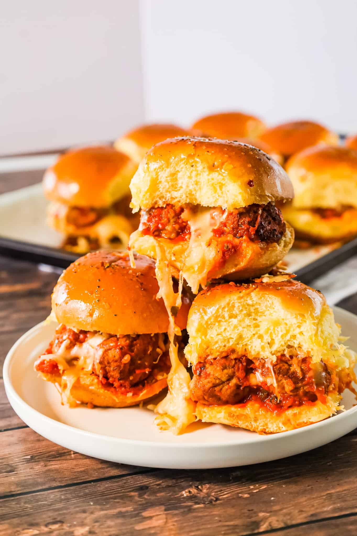 Meatball Sliders are an easy weeknight dinner recipe using frozen meatballs, marinara sauce, shredded mozzarella and parmesan cheese all baked on dinner rolls.