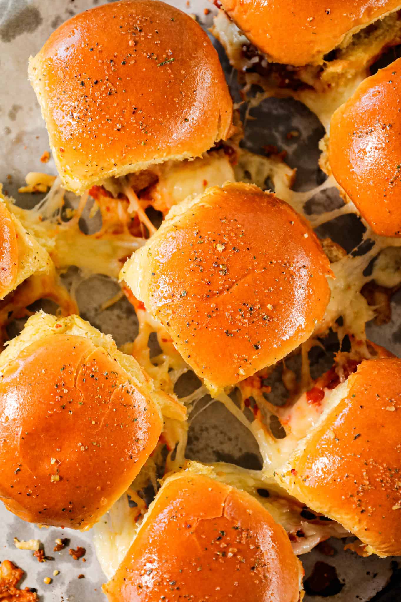 Meatball Sliders are an easy weeknight dinner recipe using frozen meatballs, marinara sauce, shredded mozzarella and parmesan cheese all baked on dinner rolls.