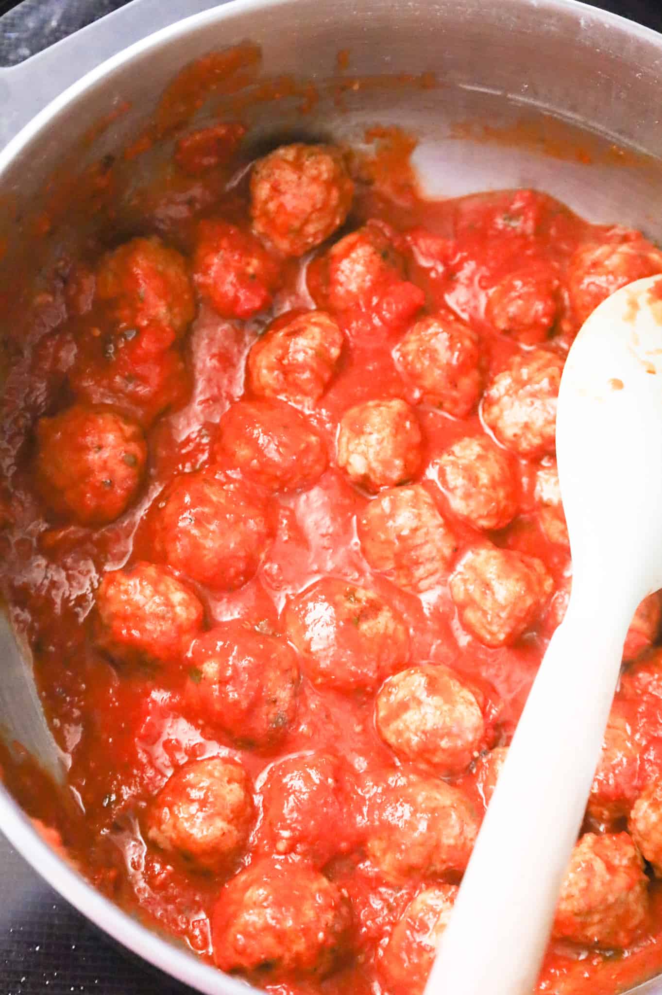 frozen meatballs tossed in marinara sauce in a pot