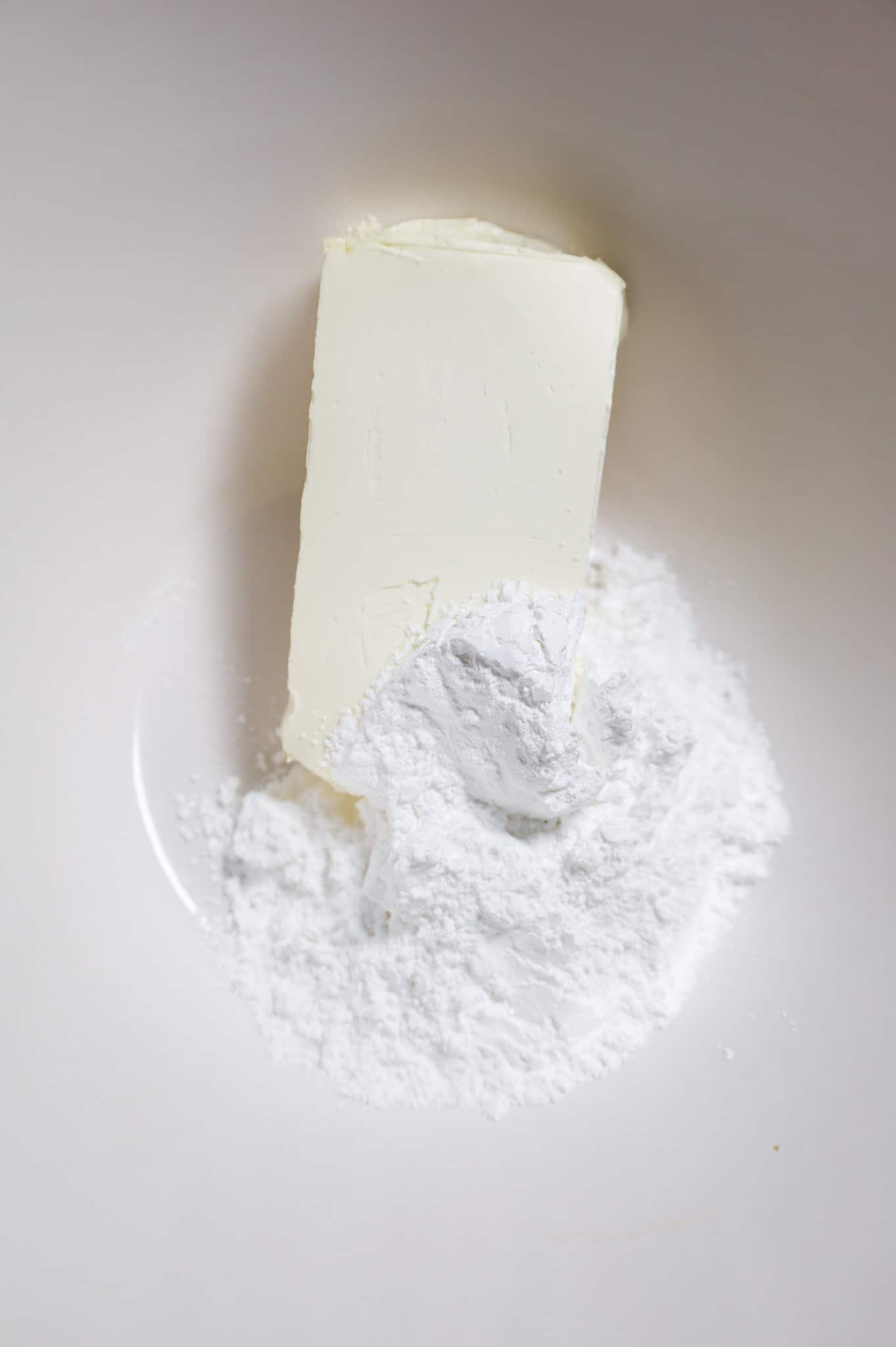 powdered sugar and cream cheese brick in a mixing bowl