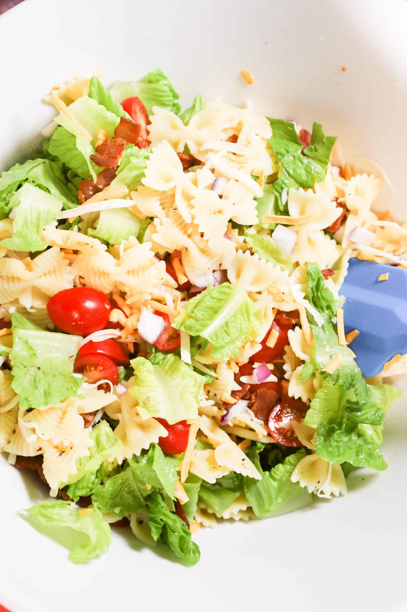 bowtie pasta mixed with chopped lettuce, tomatoes, bacon and cheese