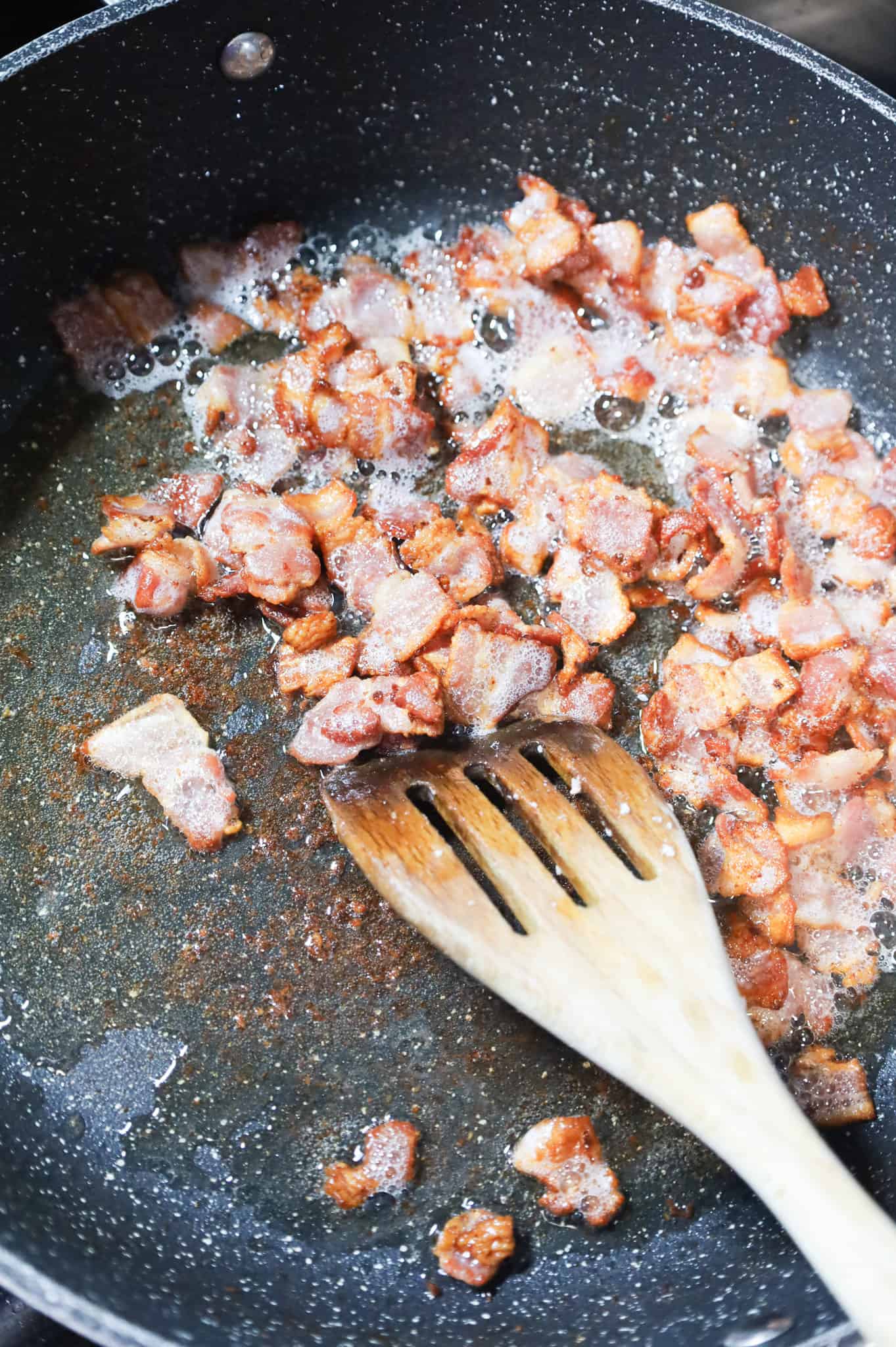 chopped bacon pieces cooking in a skillet