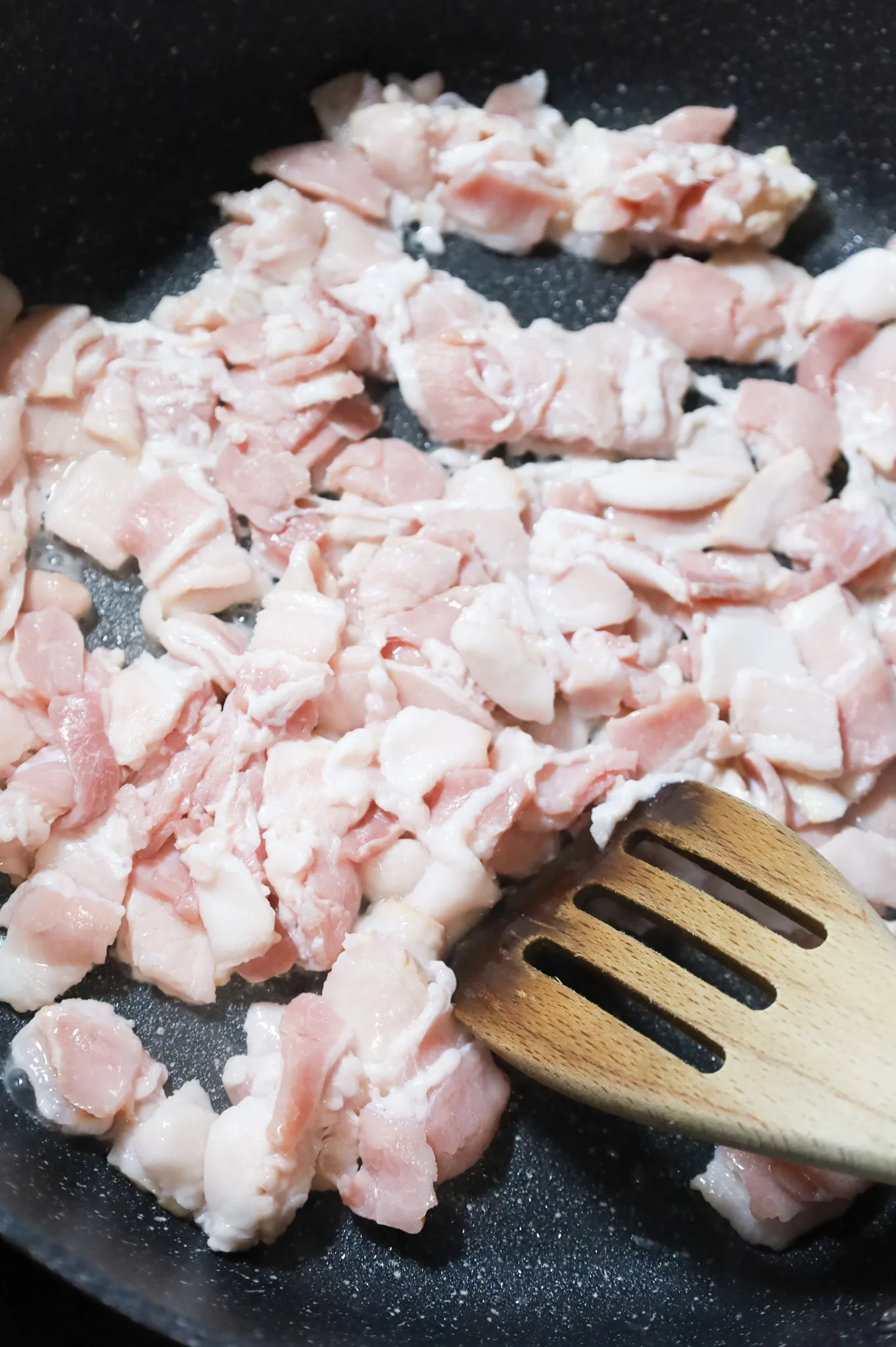 raw chopped bacon pieces in skillet