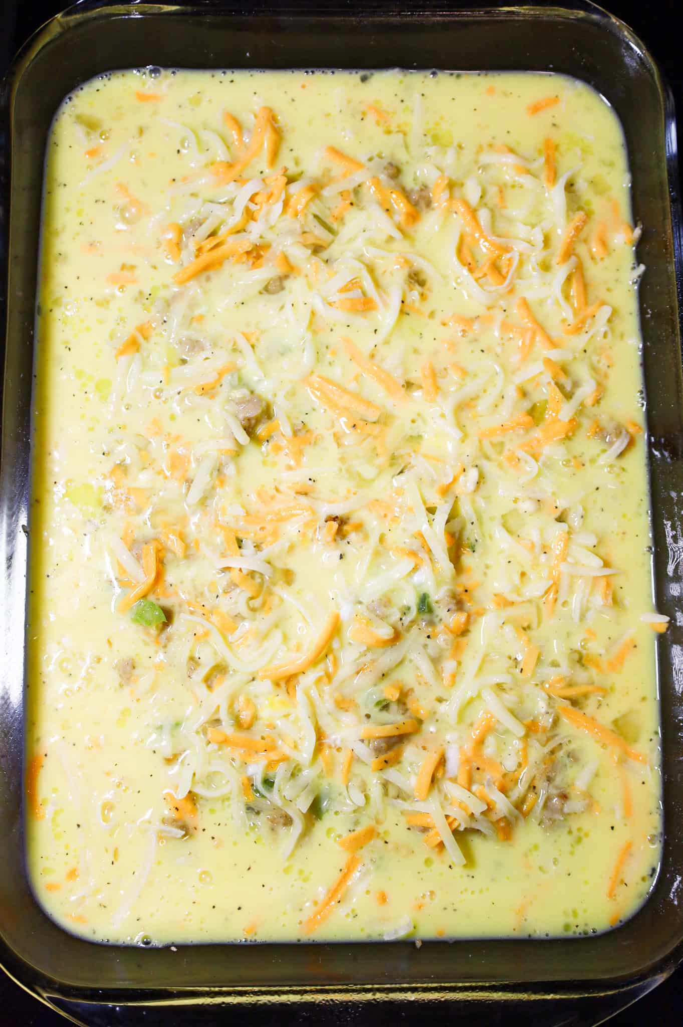 breakfast casserole with biscuits in a casserole dish before baking