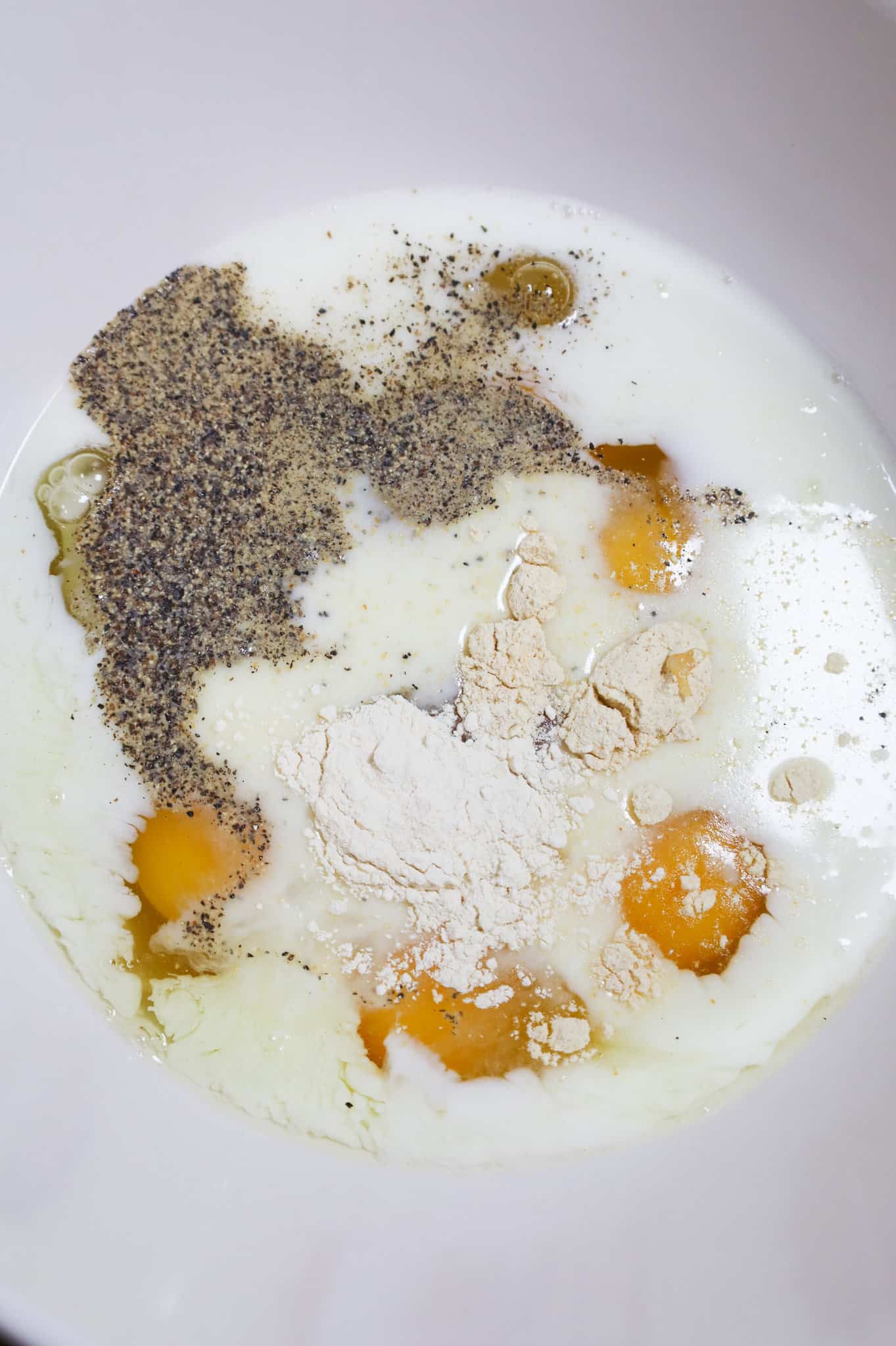 spices, milk and eggs in a mixing bowl