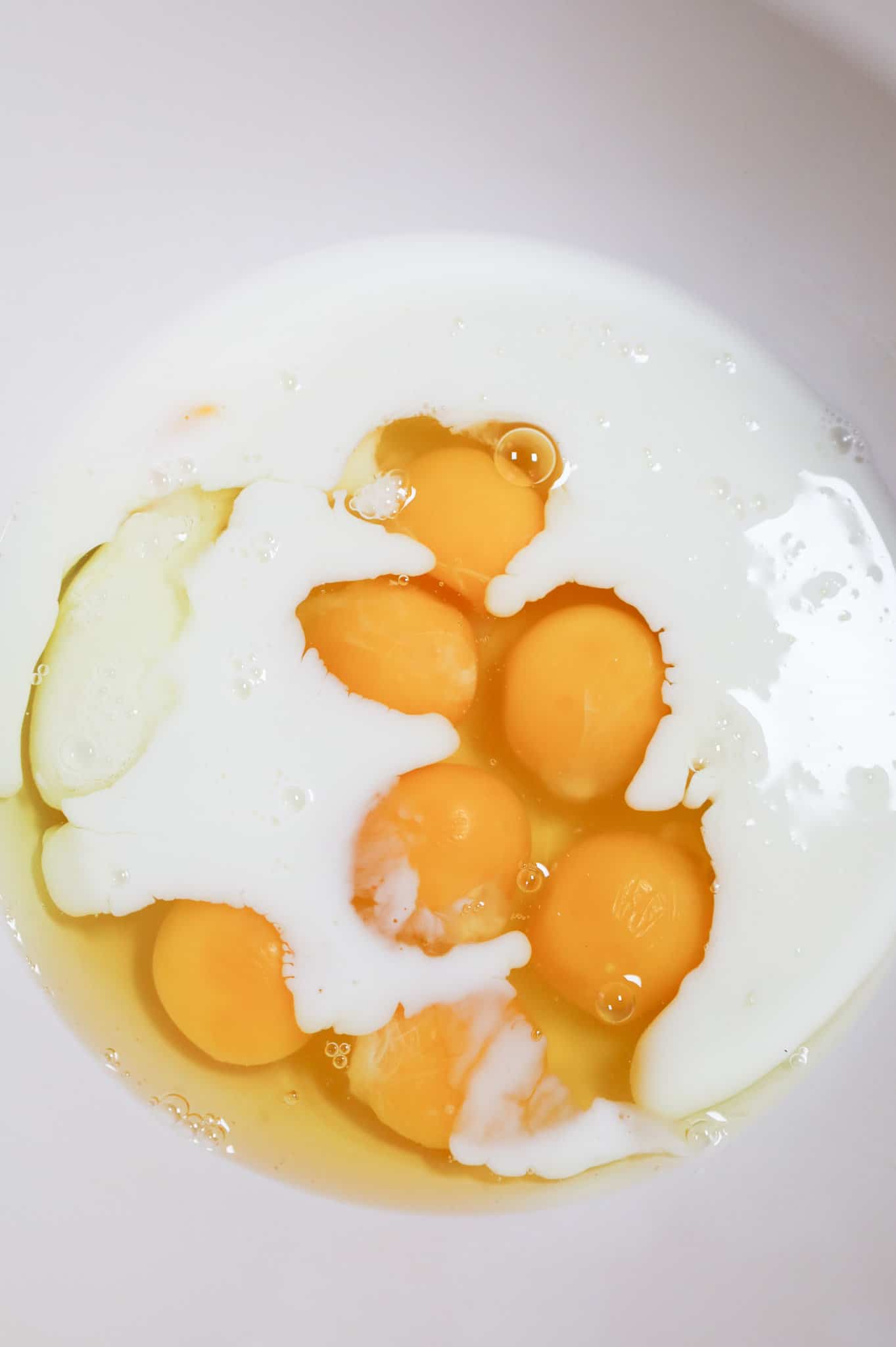 milk and eggs in a mixing bowl
