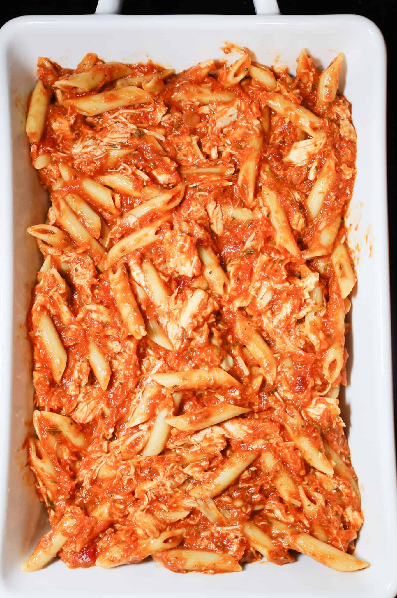 chicken penne with marinara sauce in a baking dish