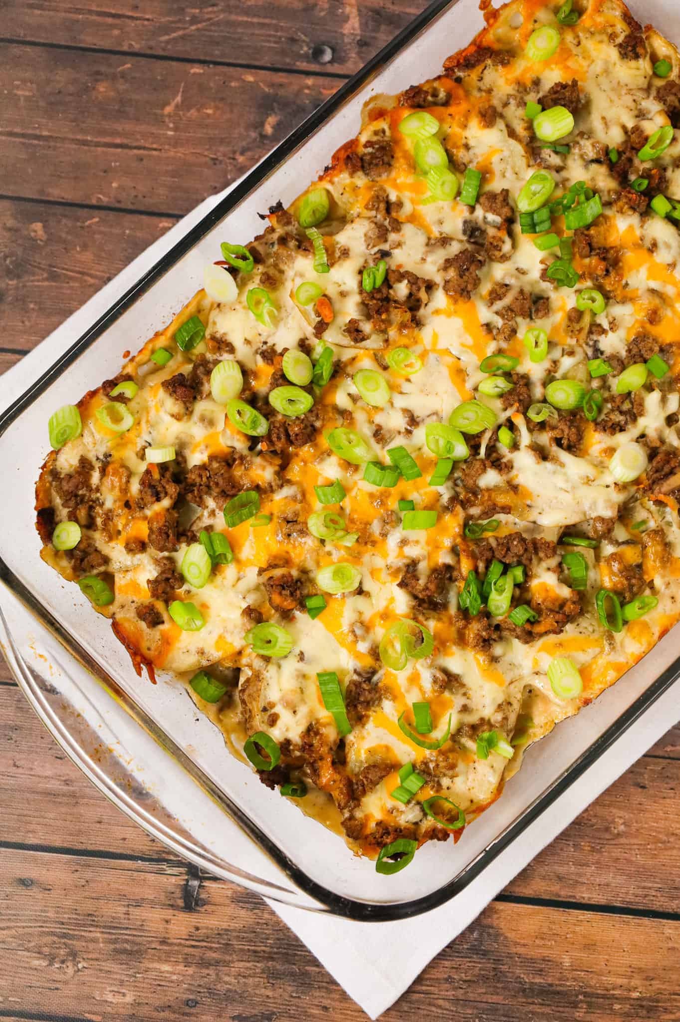 Hamburger Potato Casserole is a hearty dinner recipe with layers of sliced potatoes loaded with crumbled ground beef and shredded cheese all cooked in a cream of mushroom soup and sour cream mixture.