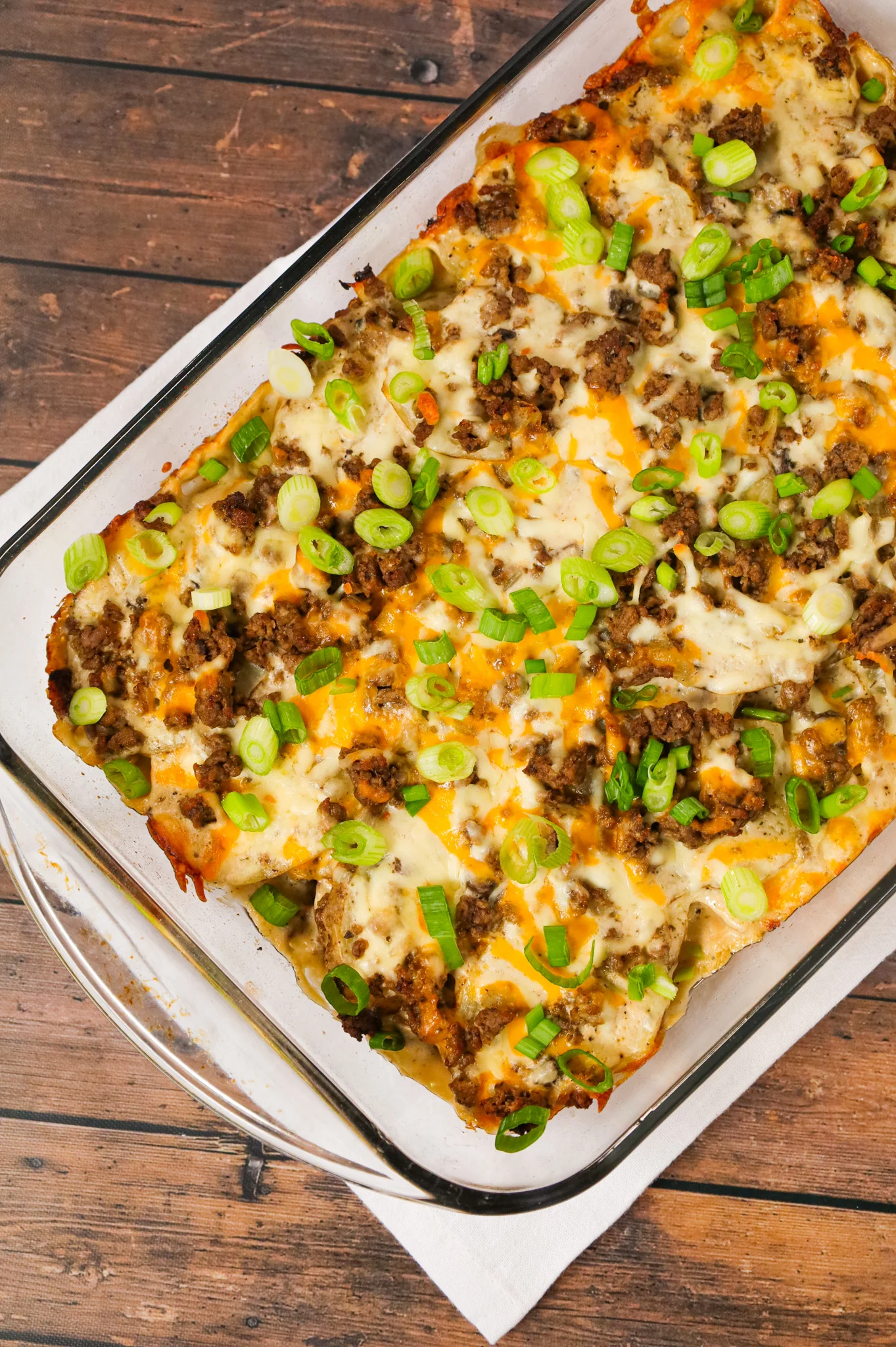 Hamburger Potato Casserole is a hearty dinner recipe with layers of sliced potatoes loaded with crumbled ground beef and shredded cheese all cooked in a cream of mushroom soup and sour cream mixture.